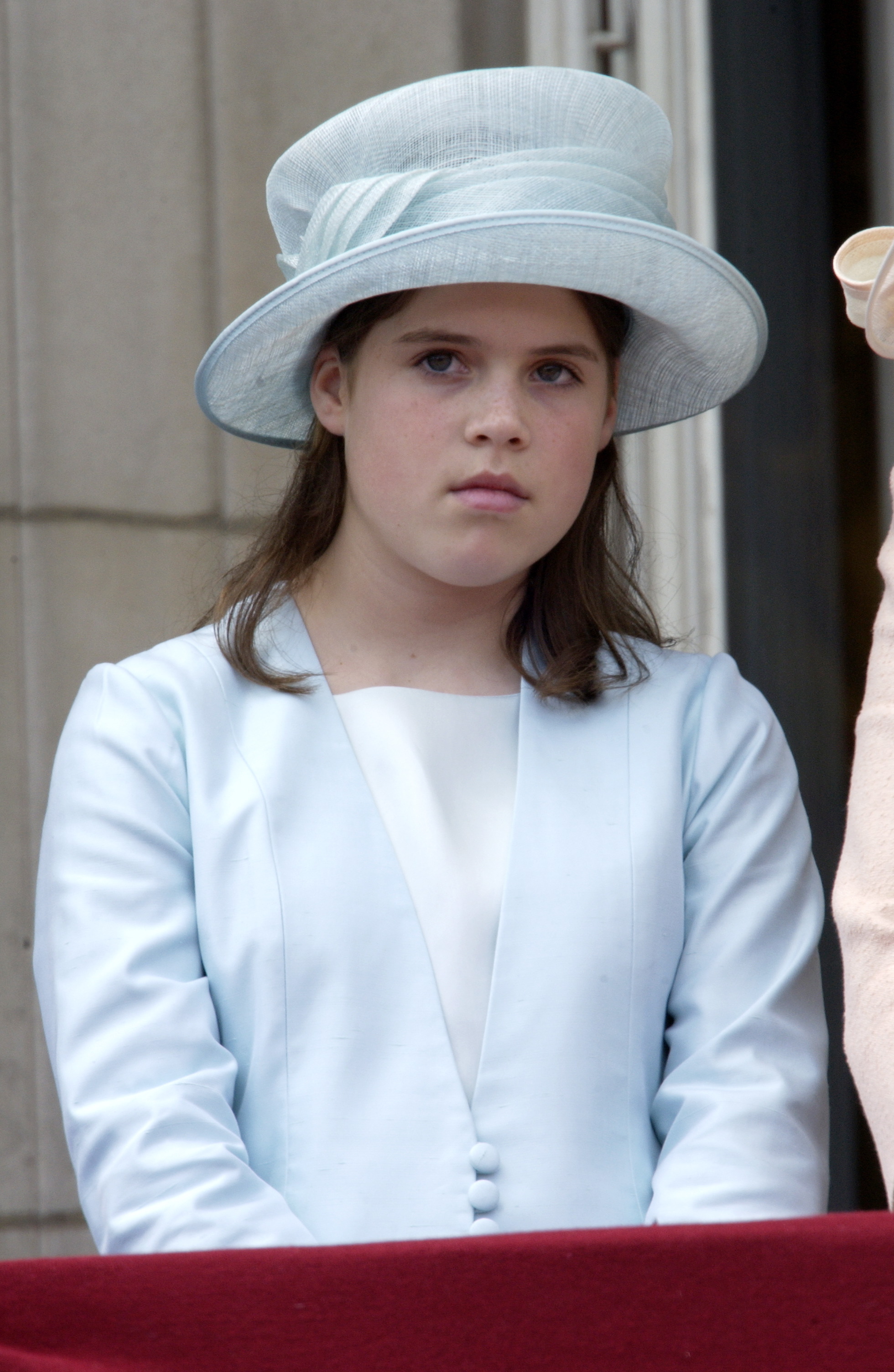 Princess Eugenie looks serious as she watches the Trooping the Colour parade from the balcony of Buckingham Palace in June 2002. | Source: Getty Images
