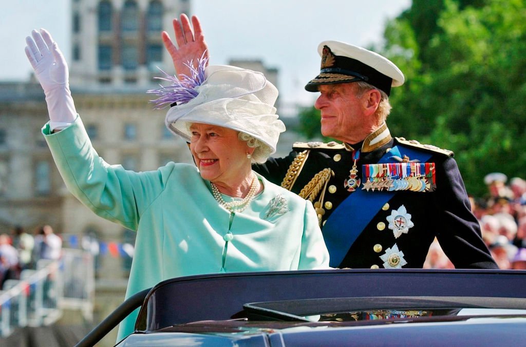 Queen Elizabeth II and Prince Phillip the Duke of Edinburgh wave to the crowd as they leave the "Recollections Of World War II Commemoration Show", an hour long show performed for thousands of World War II veterans marking the end of the World War II 60 years ago, at Horse Guards Parade on National Commemoration Day July 10, 2005, in London. | Source: Getty Images.