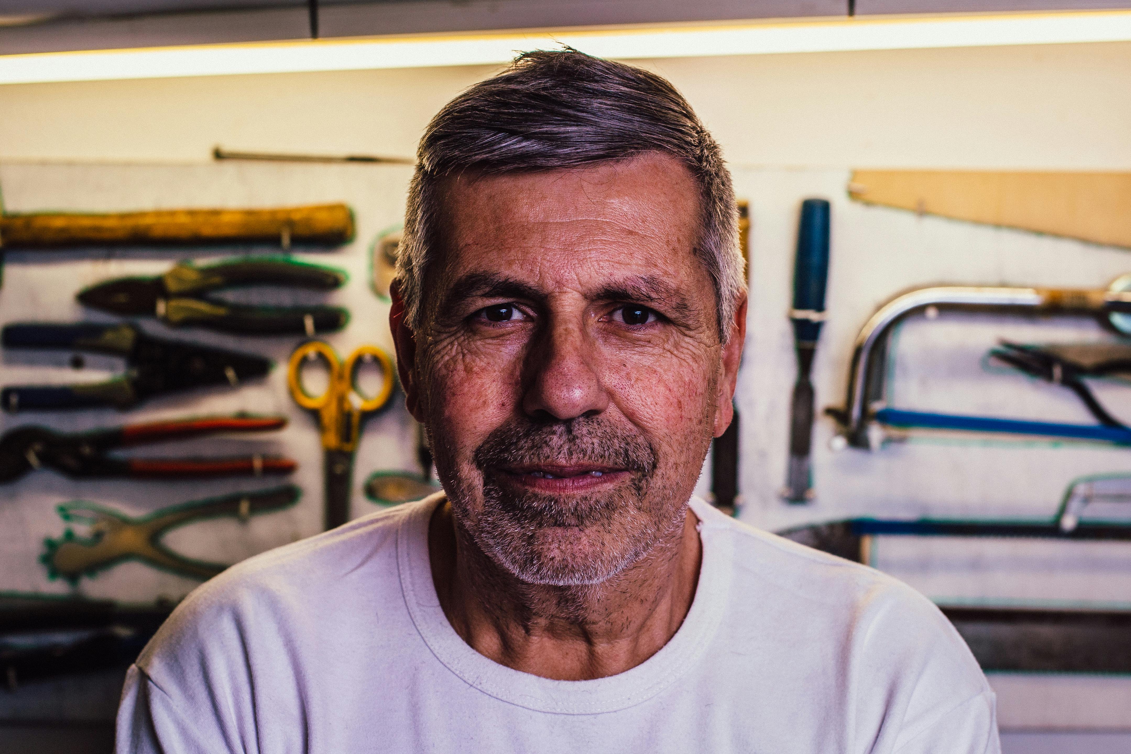 A man looking straight at the camera with tools behind him | Source: Pexels