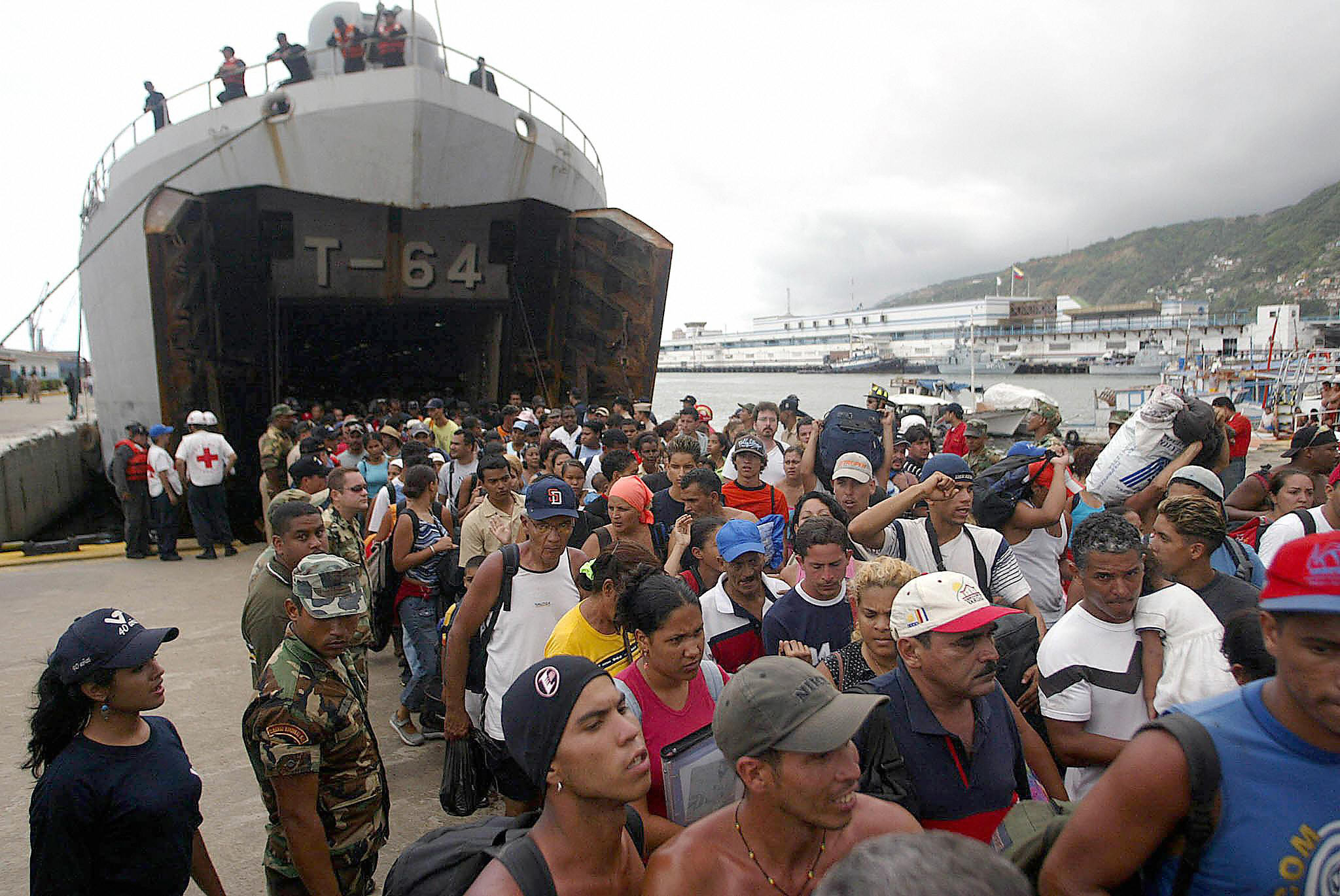 People disembarking from a ship of the Venezuelan Armed Forces at the port of La Guaira, 20 km from Caracas, after being evacuated from beaches in the state of Vargas due to flooding on February 11, 2005 | Source: Getty Images