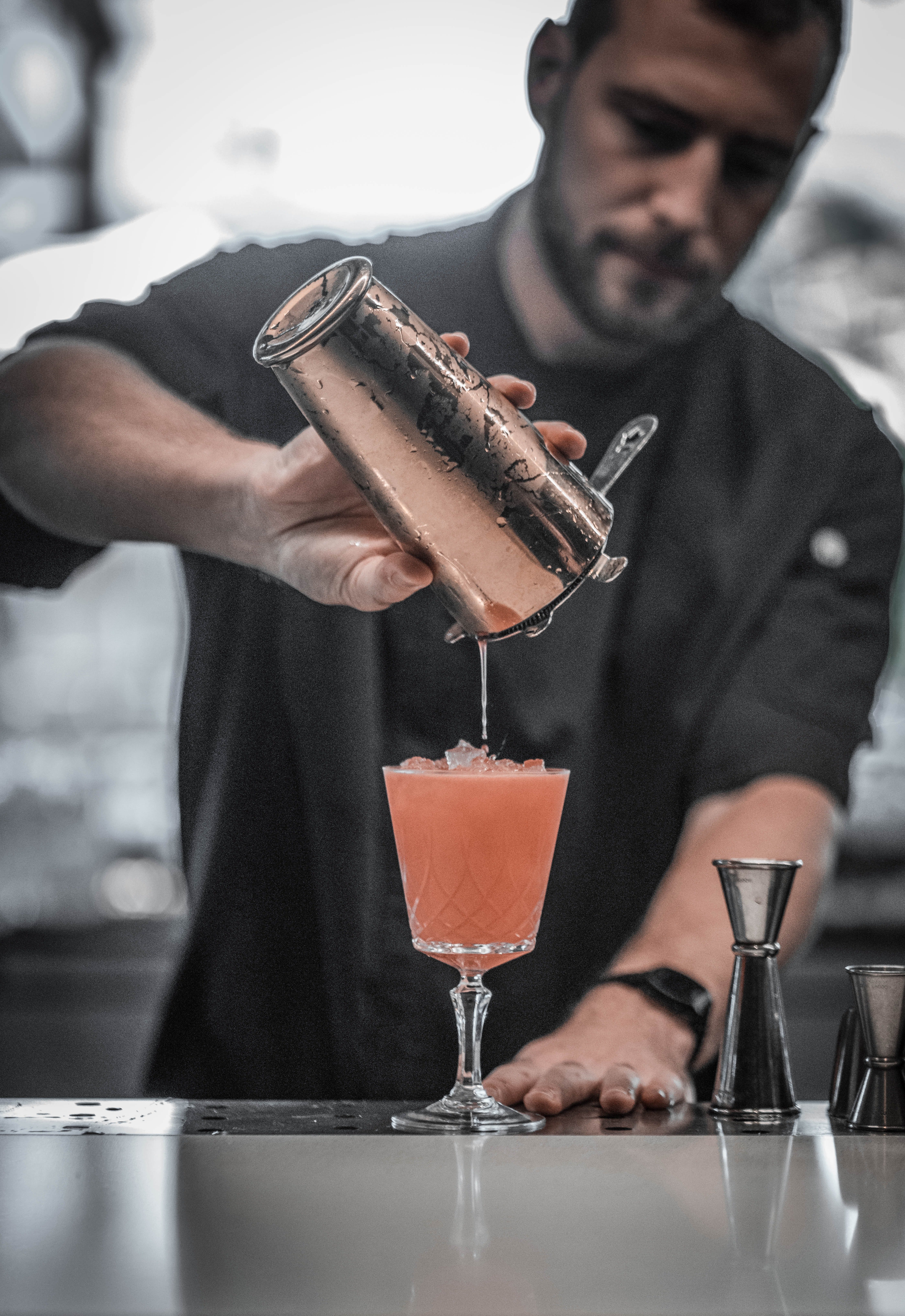 Bartender pouring drinks from behind the bar. | Photo: Pexels/ Daniel Torobekov