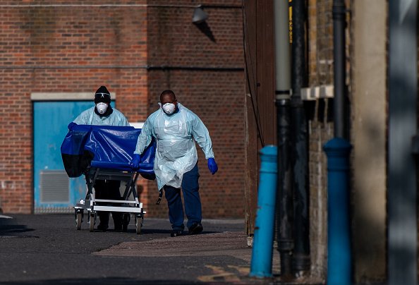 Le personnel hospitalier conduit un chariot de dissimulation, généralement utilisé pour le transport des corps. |Photo : Getty Images