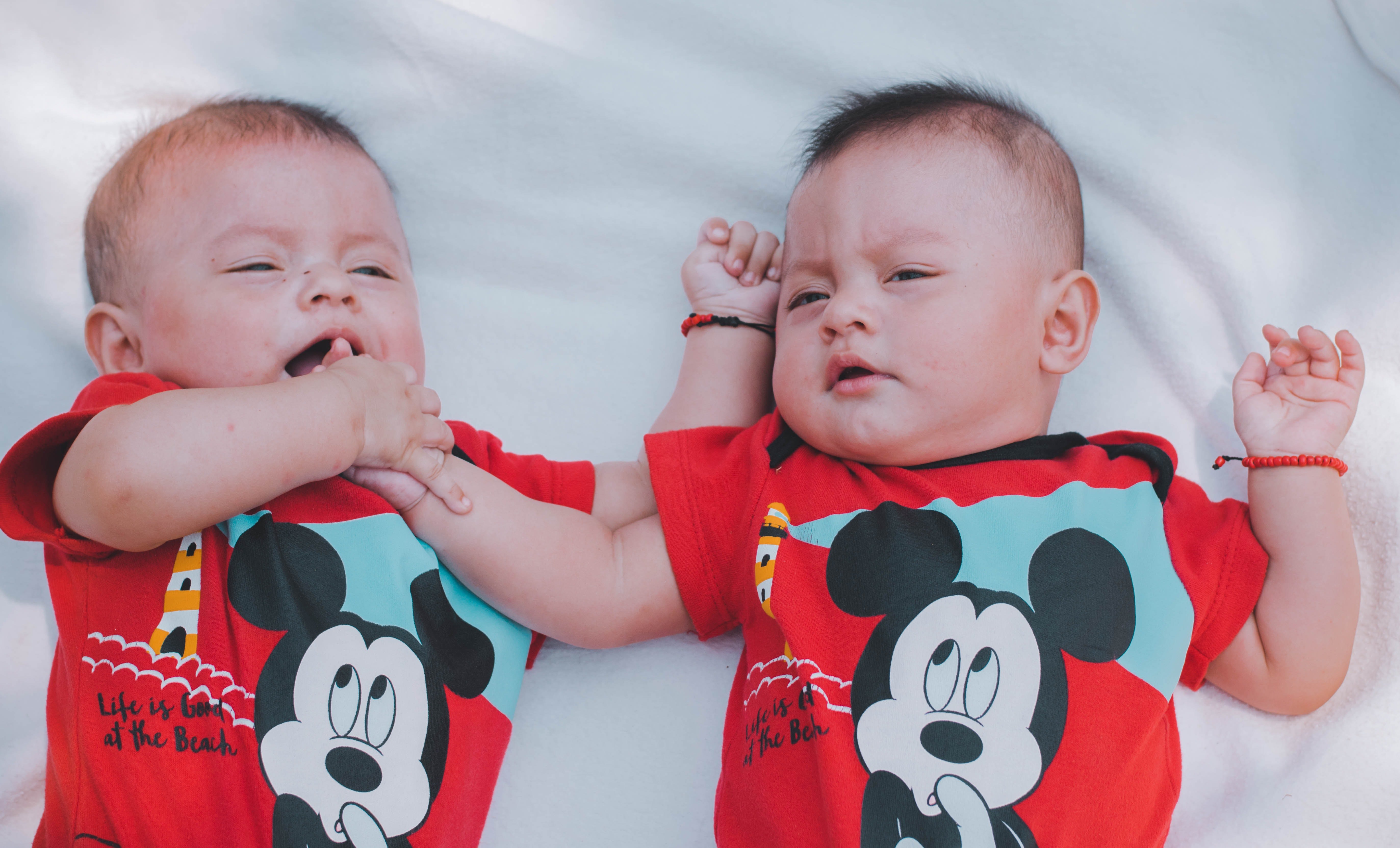 Bebés gemelos recostados en una cama. | Foto: Pexels