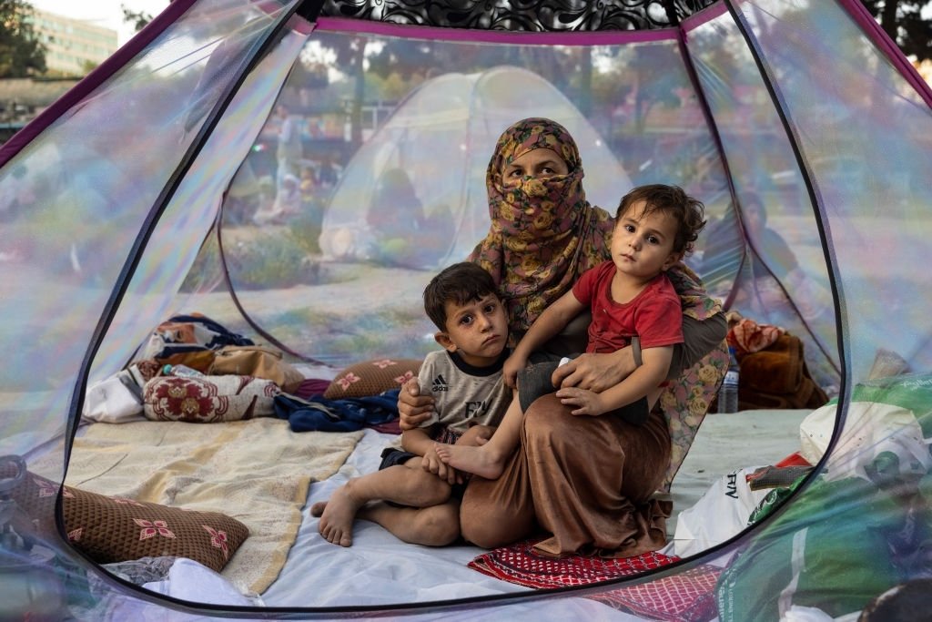 Farzia, 28 ans, qui a perdu son mari à Baghlan à cause des combats des talibans, est assise avec ses enfants dans une tente. | Photo : Getty Images
