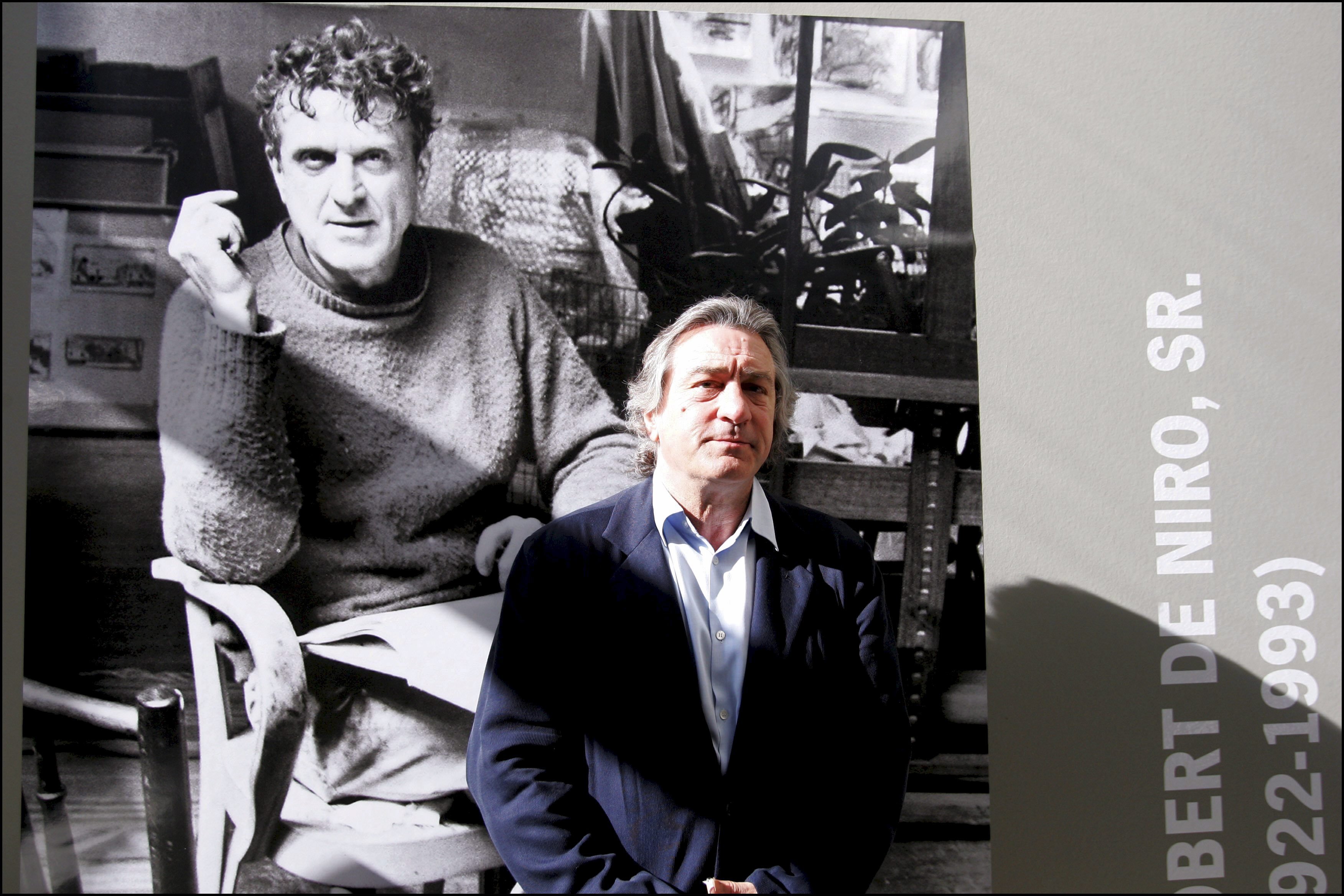 Robert De Niro posiert neben einem Porträt seines Vaters Robert Sr. in einer Ausstellung von Robert De Niro Sr. – Gemälde im La Piscine in Roubaix, Frankreich am 18. Juni 2005 | Quelle: Getty Images