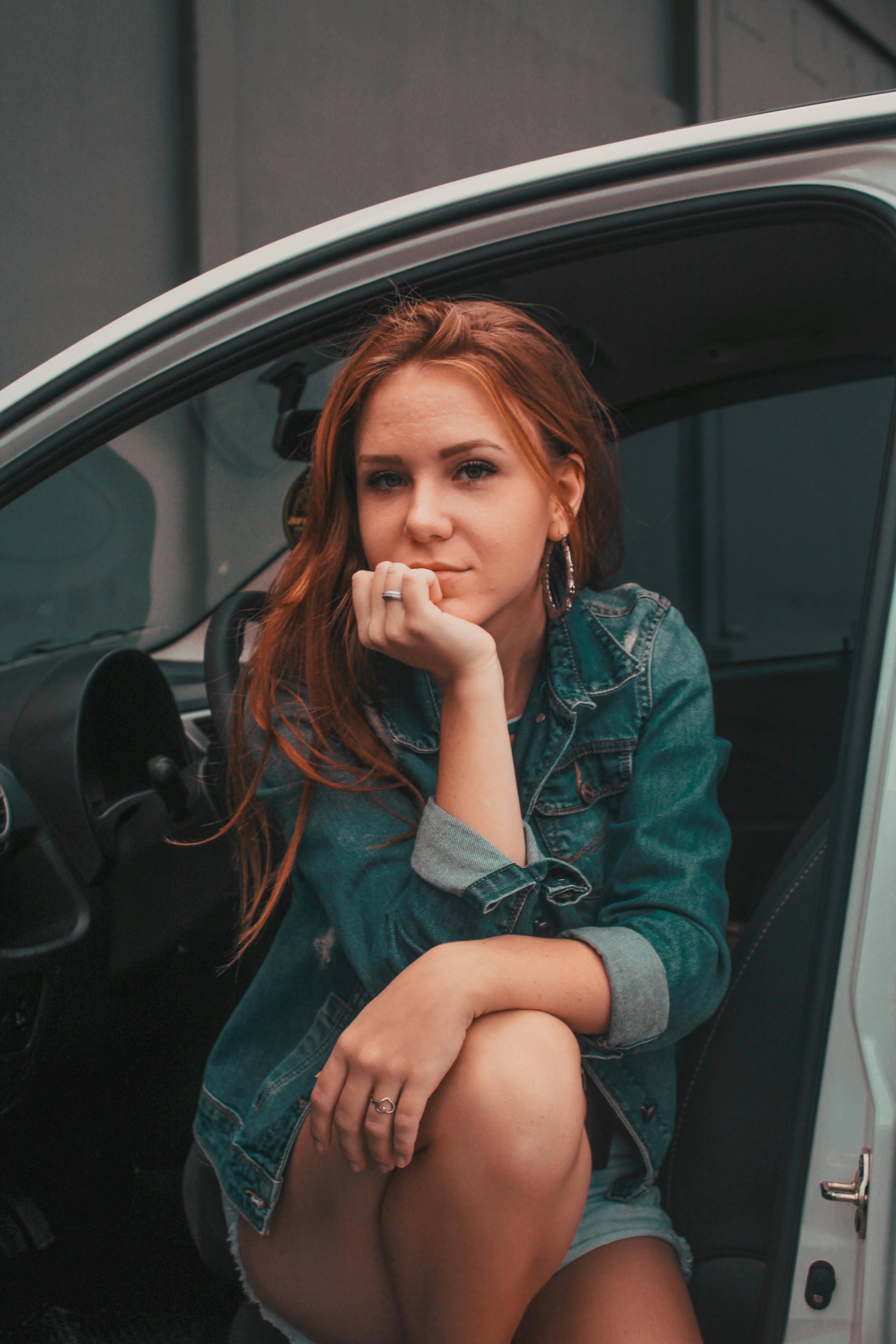 A woman sitting with her car's door open while contemplating something | Source: Pexels