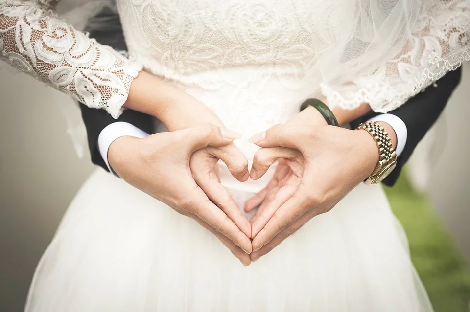 Pareja de novios haciendo un corazón con sus manos. | Foto: Pixabay
