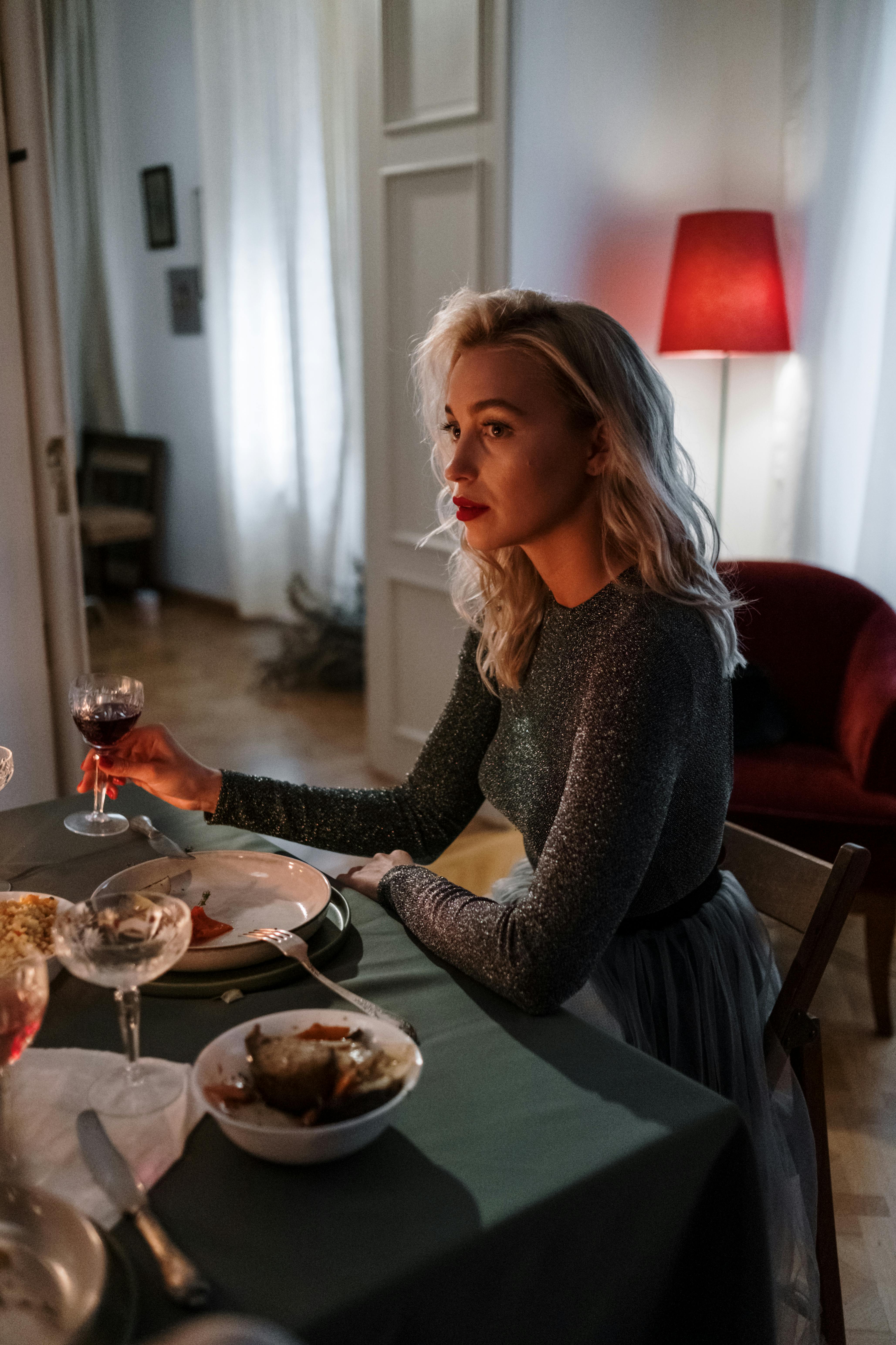Woman holding a glass of wine during dinner | Source: Pexels