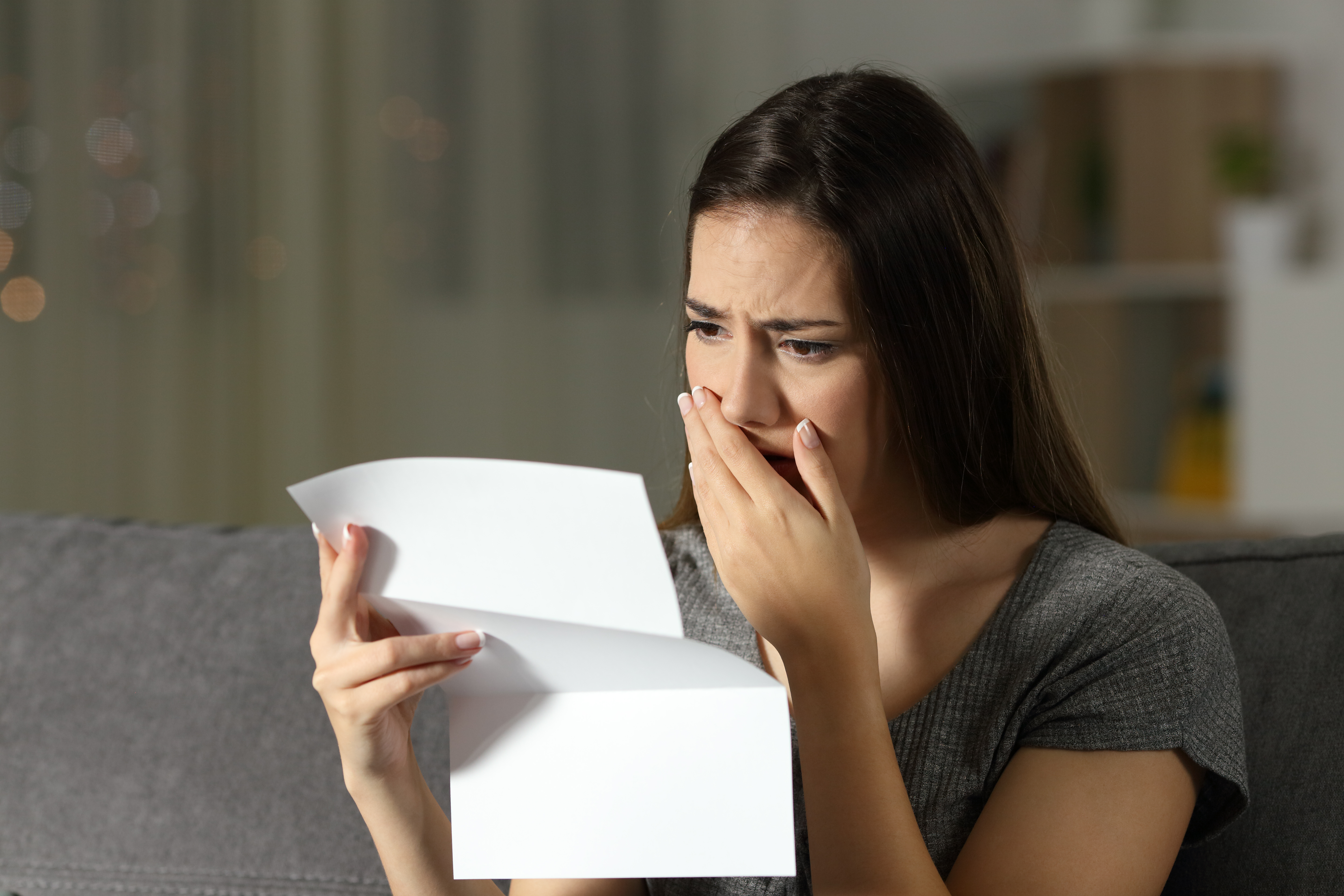 Sad woman complaining reading a letter. | Source: Shutterstock