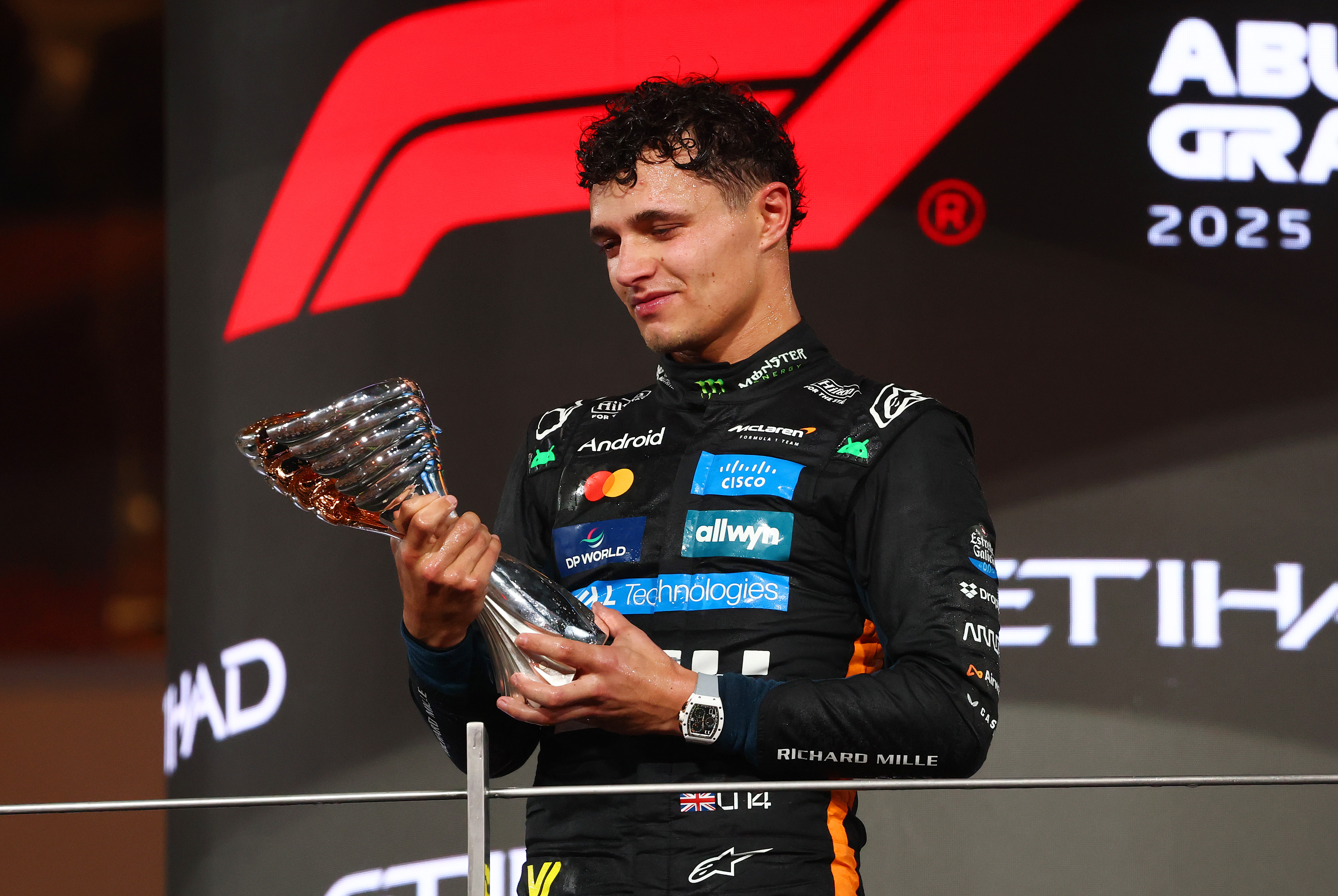 Lando Norris of Great Britain inspects his trophy on the podium during the F1 Grand Prix of Abu Dhabi at Yas Marina Circuit on December 07, 2025 in Abu Dhabi, United Arab Emirates | Source: Getty Images
