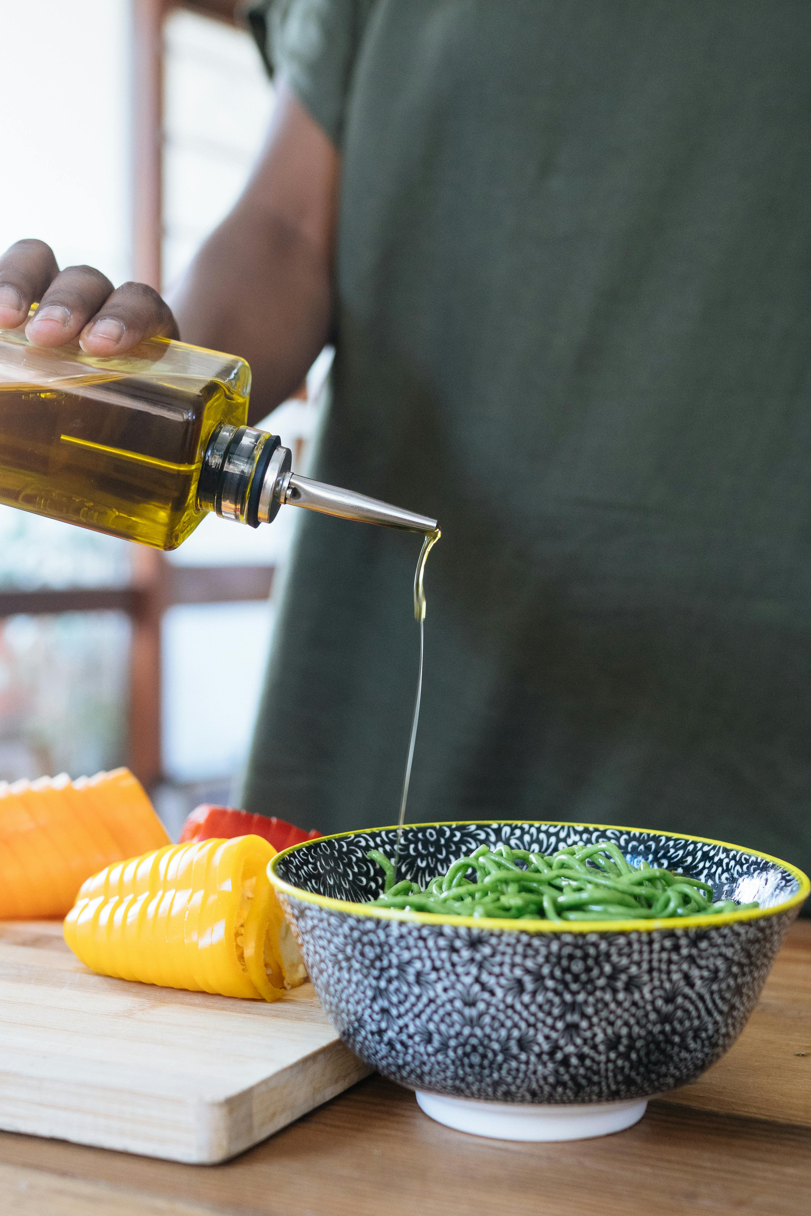 A person pouring olive oil on their food | Source: Pexels