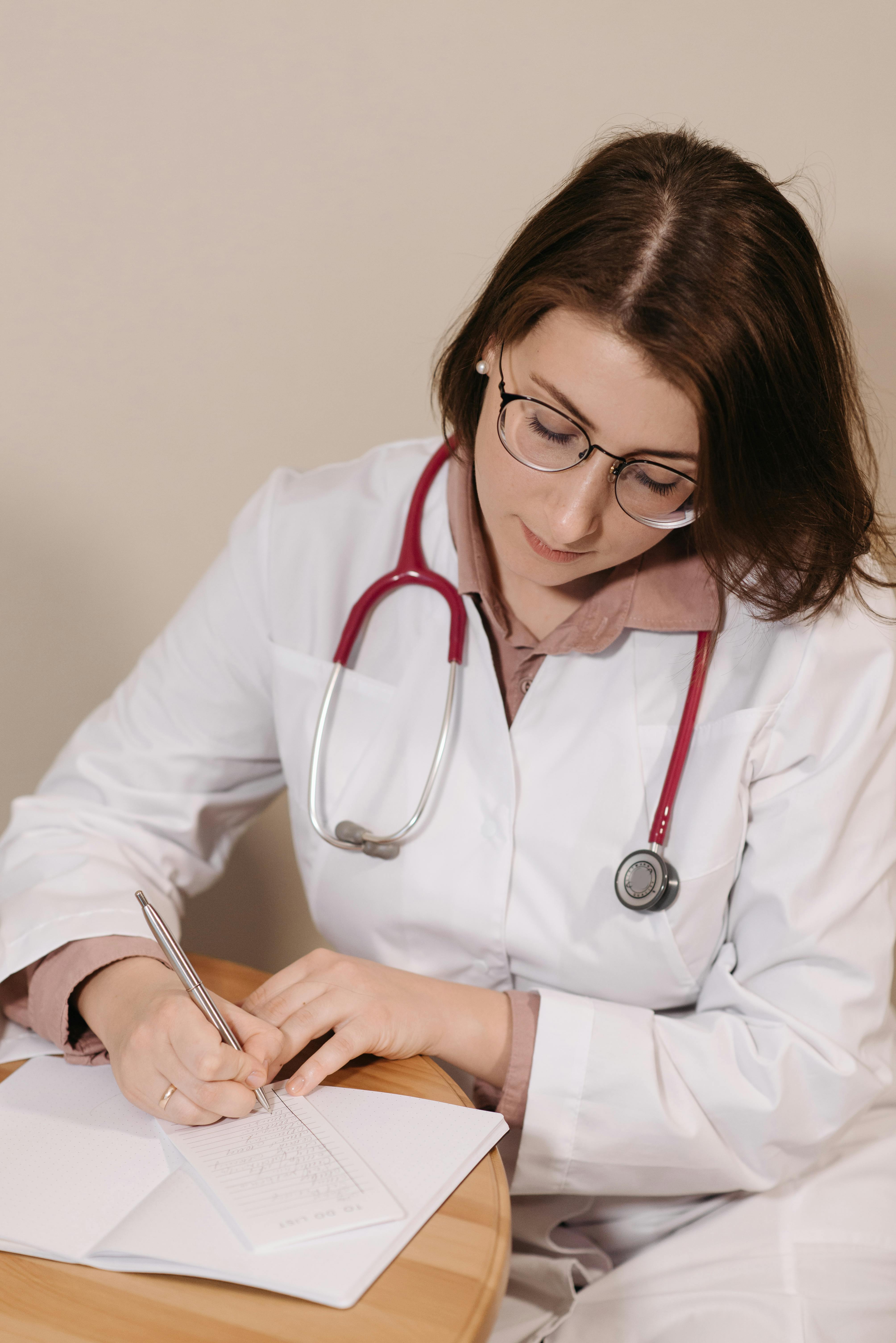 A doctor writing something down | Source: Pexels