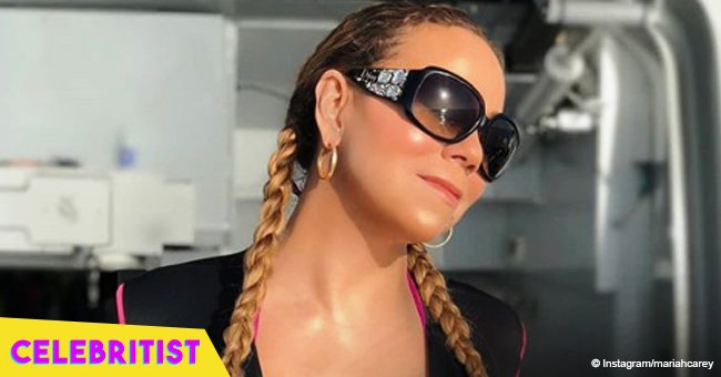 Mariah Carey flaunts deep cleavage in striped dress, posing with longtime boyfriend in photo