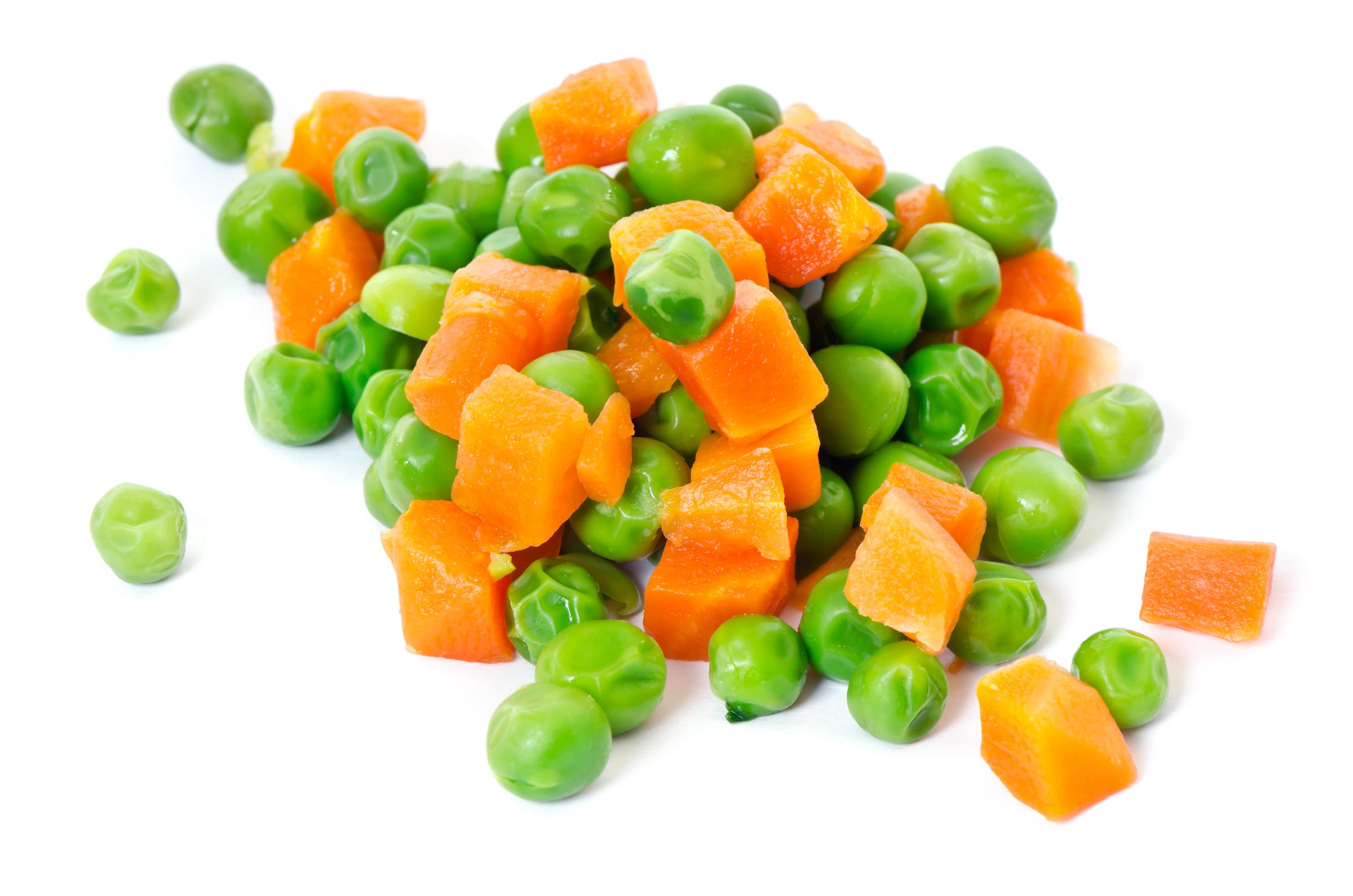 Macro pile of peas and carrots on white | Source: Getty Images