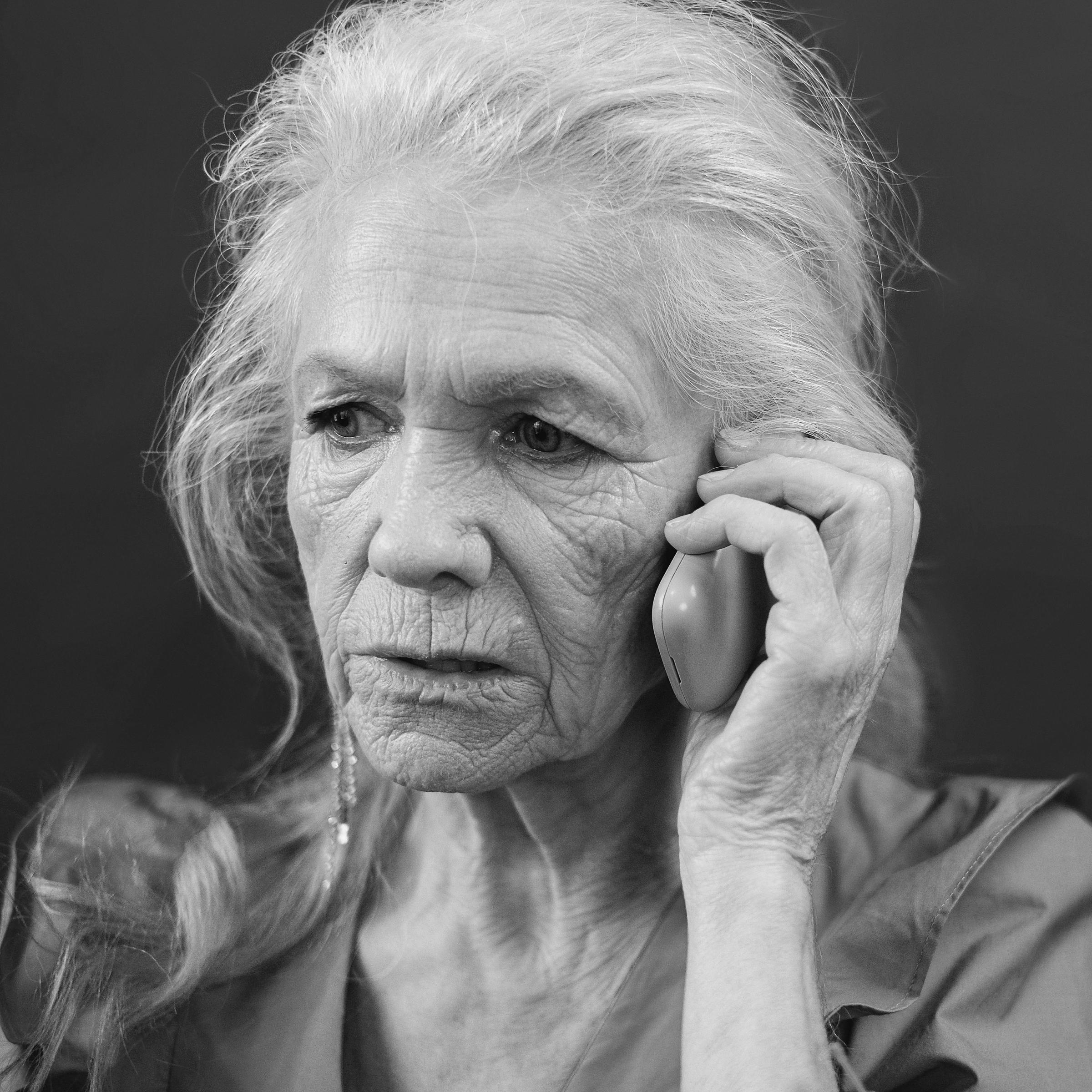 A worried-looking older woman in conversation on a mobile phone | Source: Midjourney