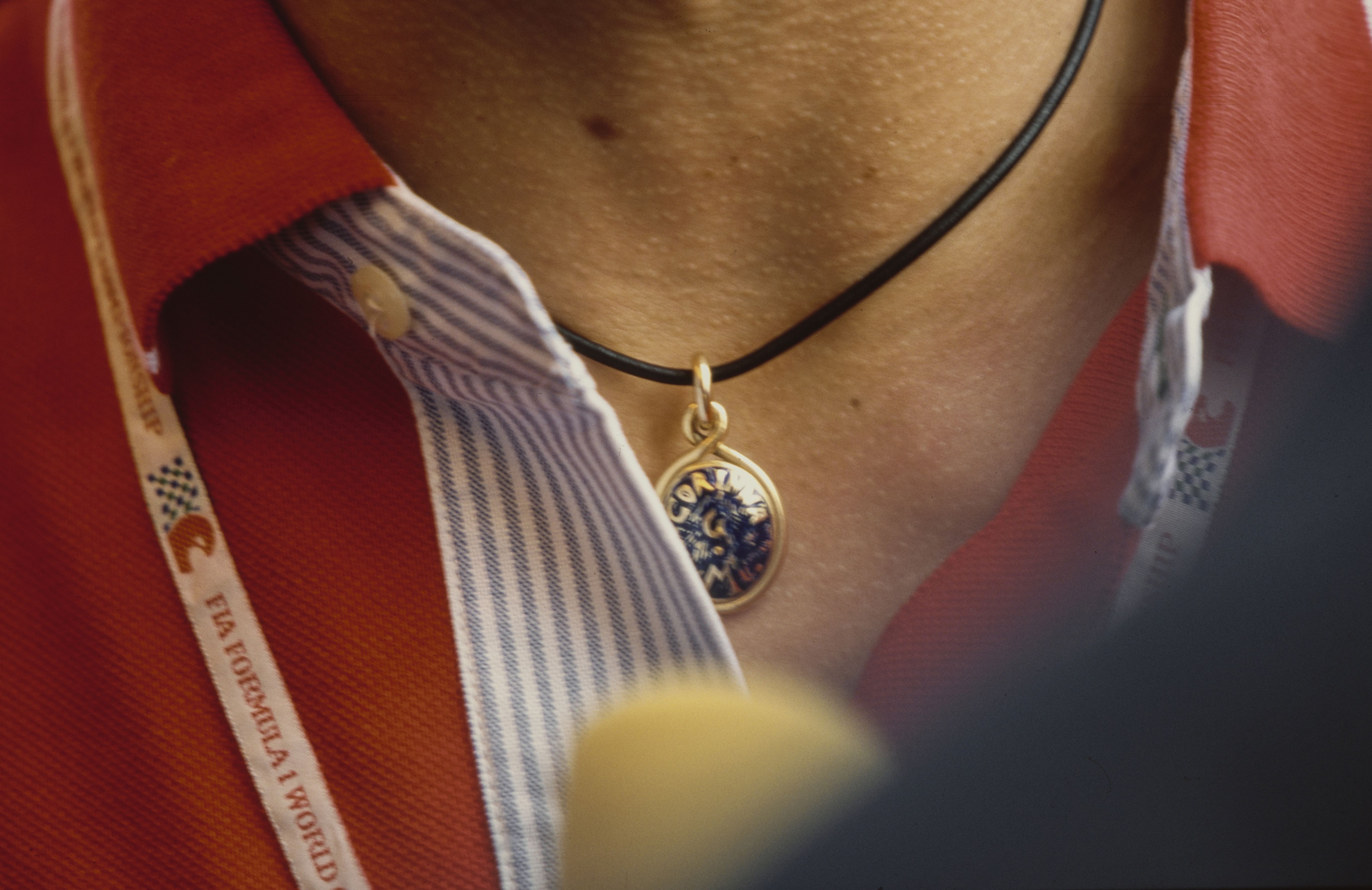 Close-up view of the pendant bearing the name of his wife, Corinna Schumacher, worn by German racing driver Michael Schumacher ahead of the German Grand Prix, held at Hockenheimring, in Hockenheim, Baden-Wurttemberg, Germany, August 2, 1998. | Source: Getty Images