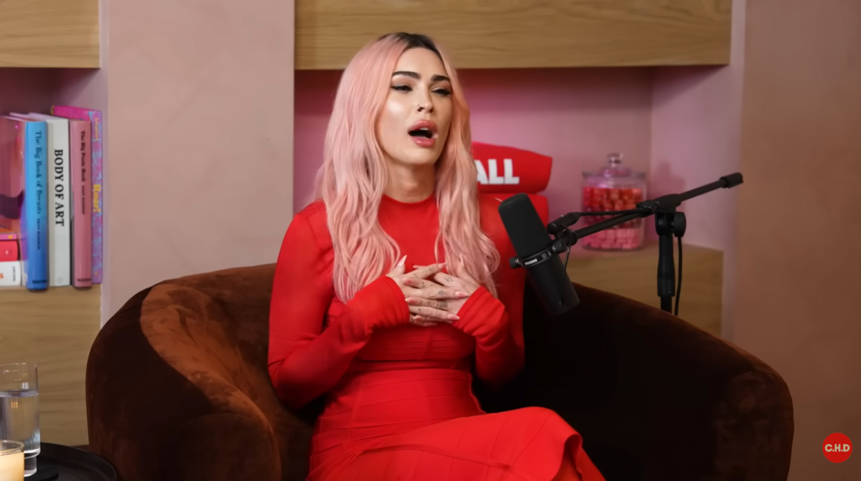 Megan Fox speaks during the interview while seated in the studio wearing a red outfit | Source: YouTube/callherdaddy