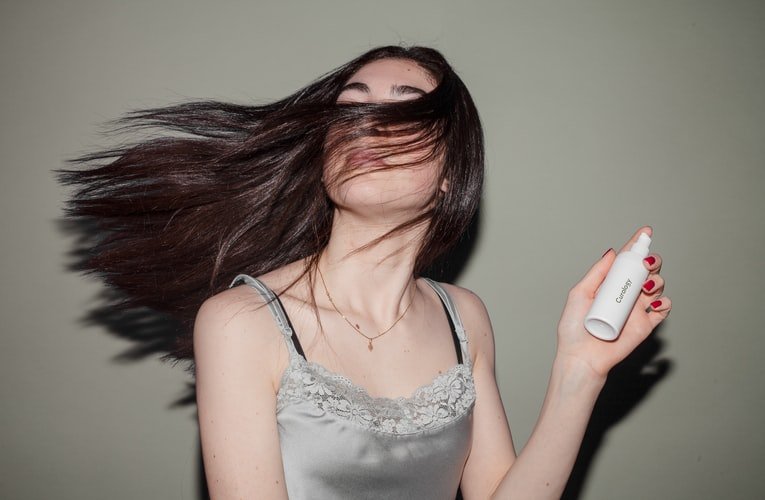 A photo of a woman using a spray. | Photo: Unsplash