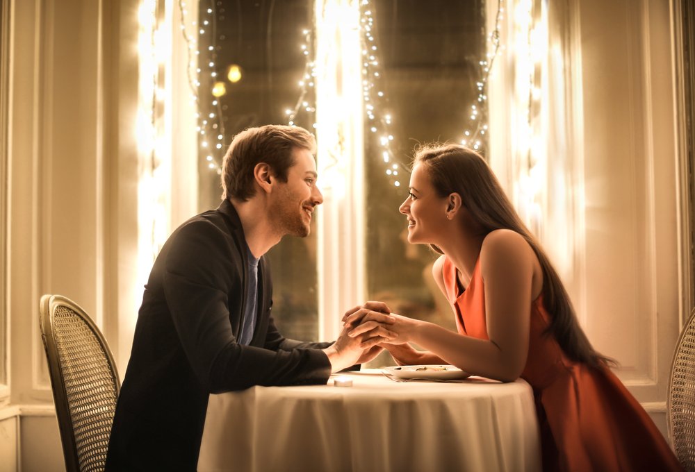 Dulce pareja teniendo una cena romántica. | Fuente: Shutterstock Dulce pareja teniendo una cena romántica. | Fuente: Shutterstock