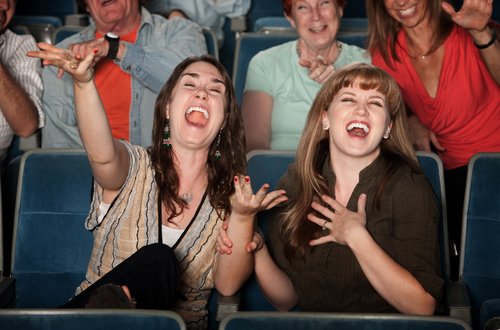 Des femmes riant dans un théâtre. | Source : Shutterstock.