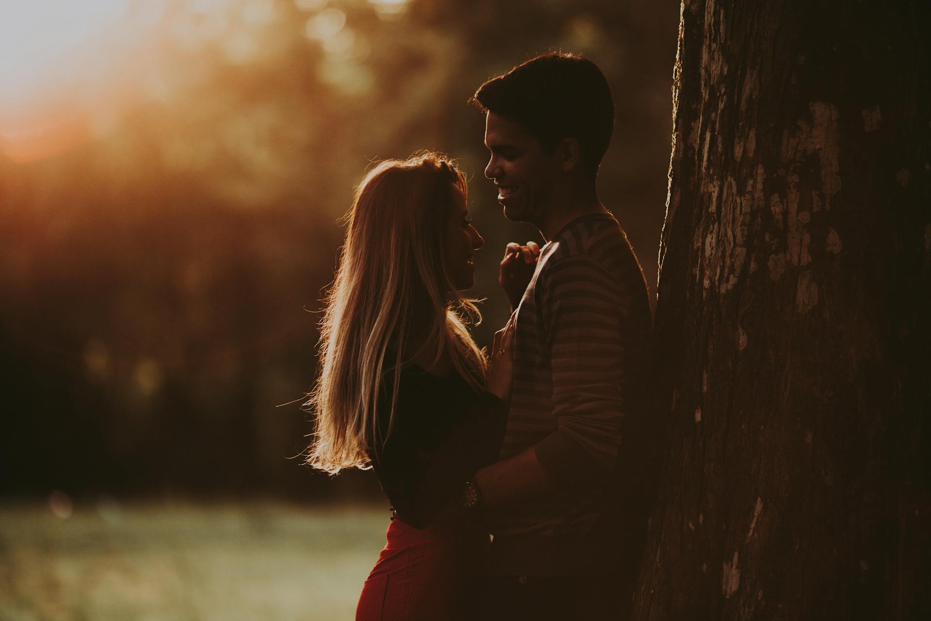 A couple standing close near a tree | Source: Pexels