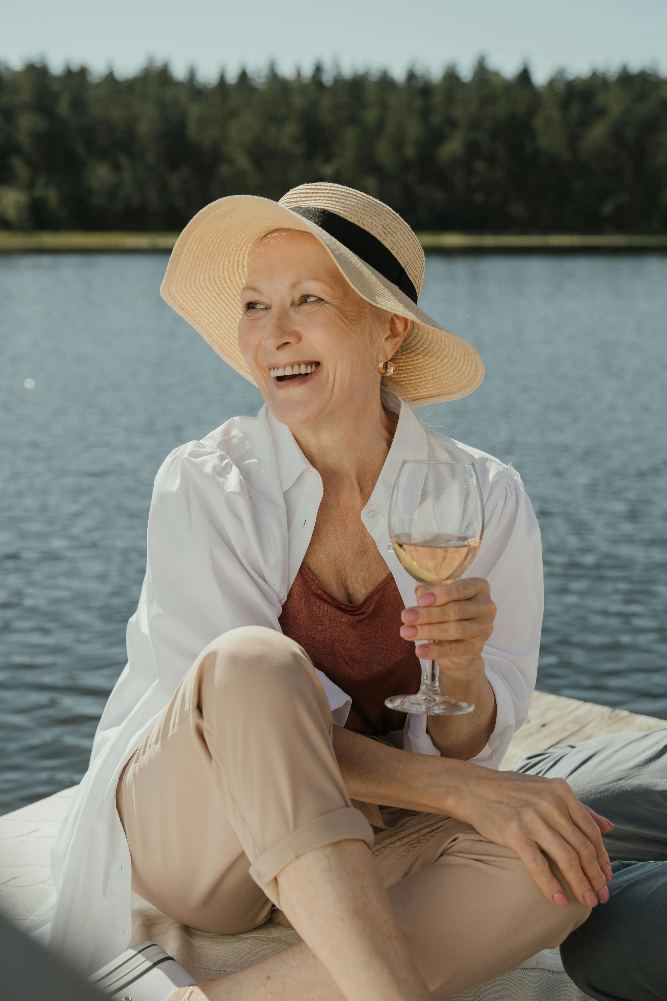Happy senior woman holding a glass of wine | Source: Pexels