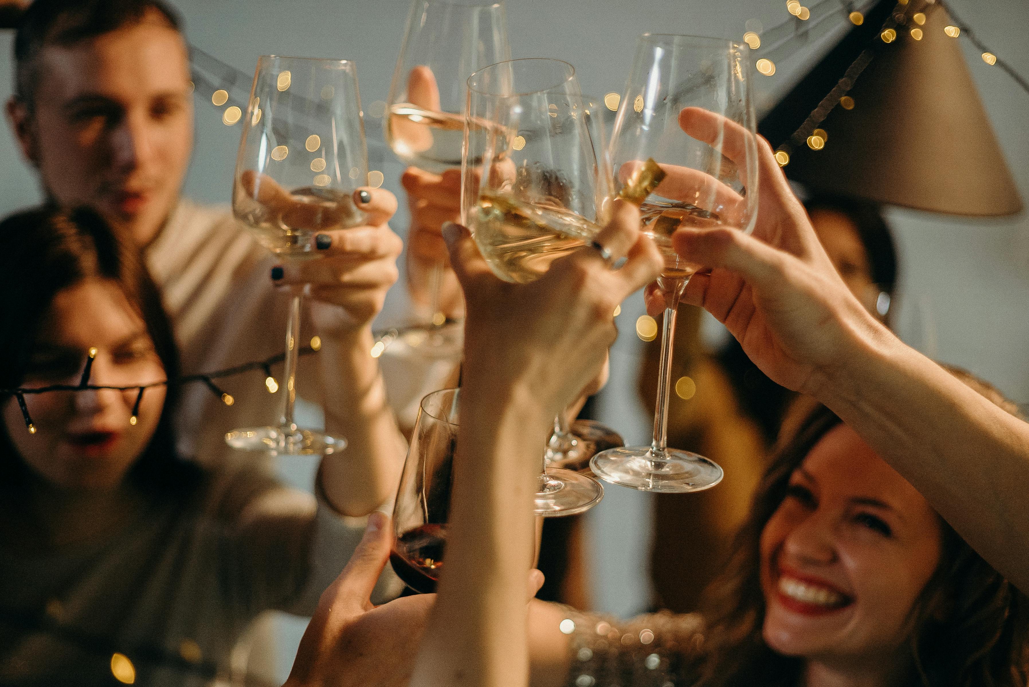 People holding their glasses up during a toast | Source: Pexels