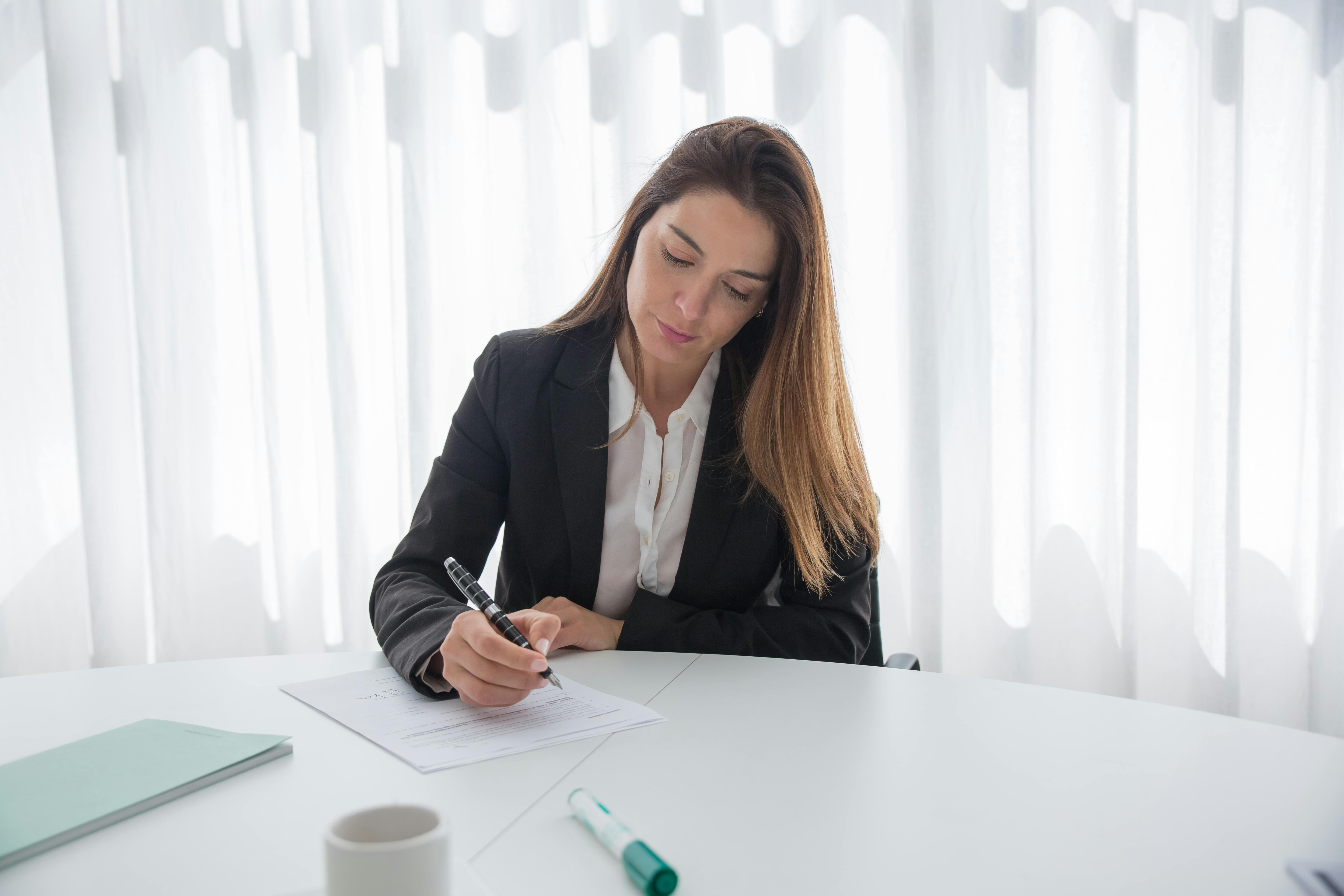 Woman signing documents | Source: Pexels