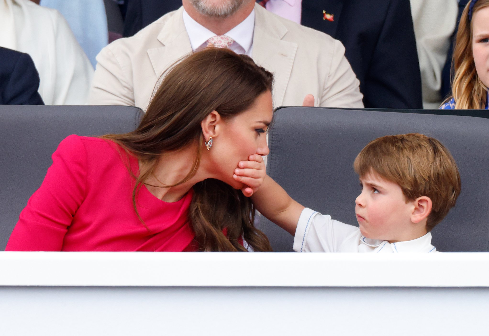 El príncipe Louis cubre la boca de su madre Catherine, duquesa de Cambridge con su mano mientras asisten al desfile de Platino 5 de junio de 2022 en Londres, Inglaterra. | Foto: Getty Images