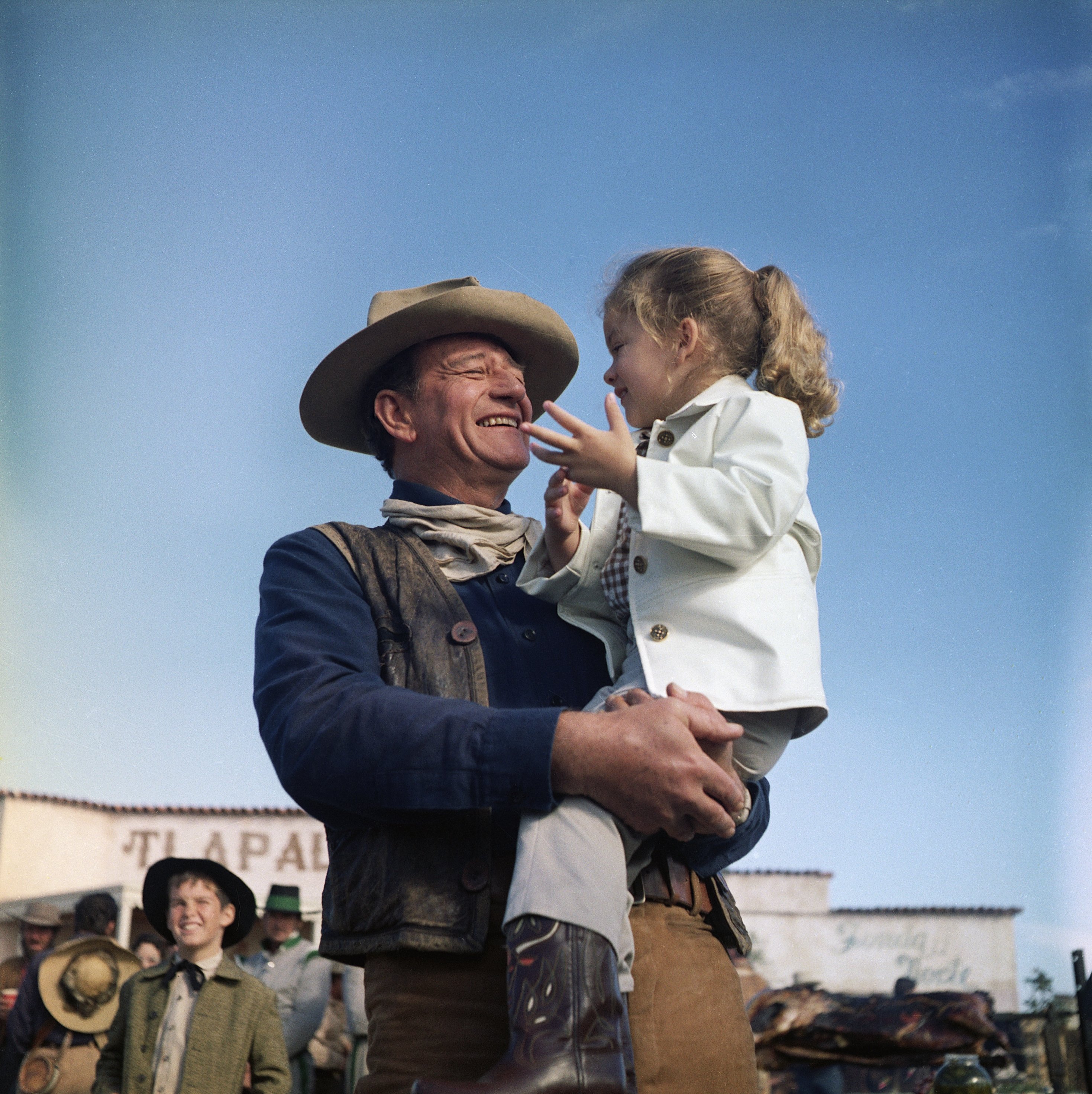 John Wayne holds his daughter, Aissa, on the set of "The Alamo." on September 29 1960 | Source: Getty Images