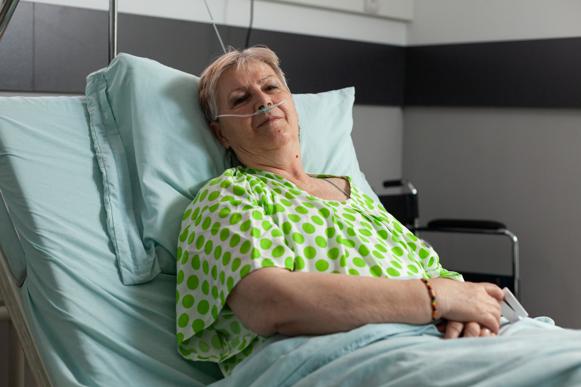An ailing senior woman lying on a hospital bed | Source: Freepik