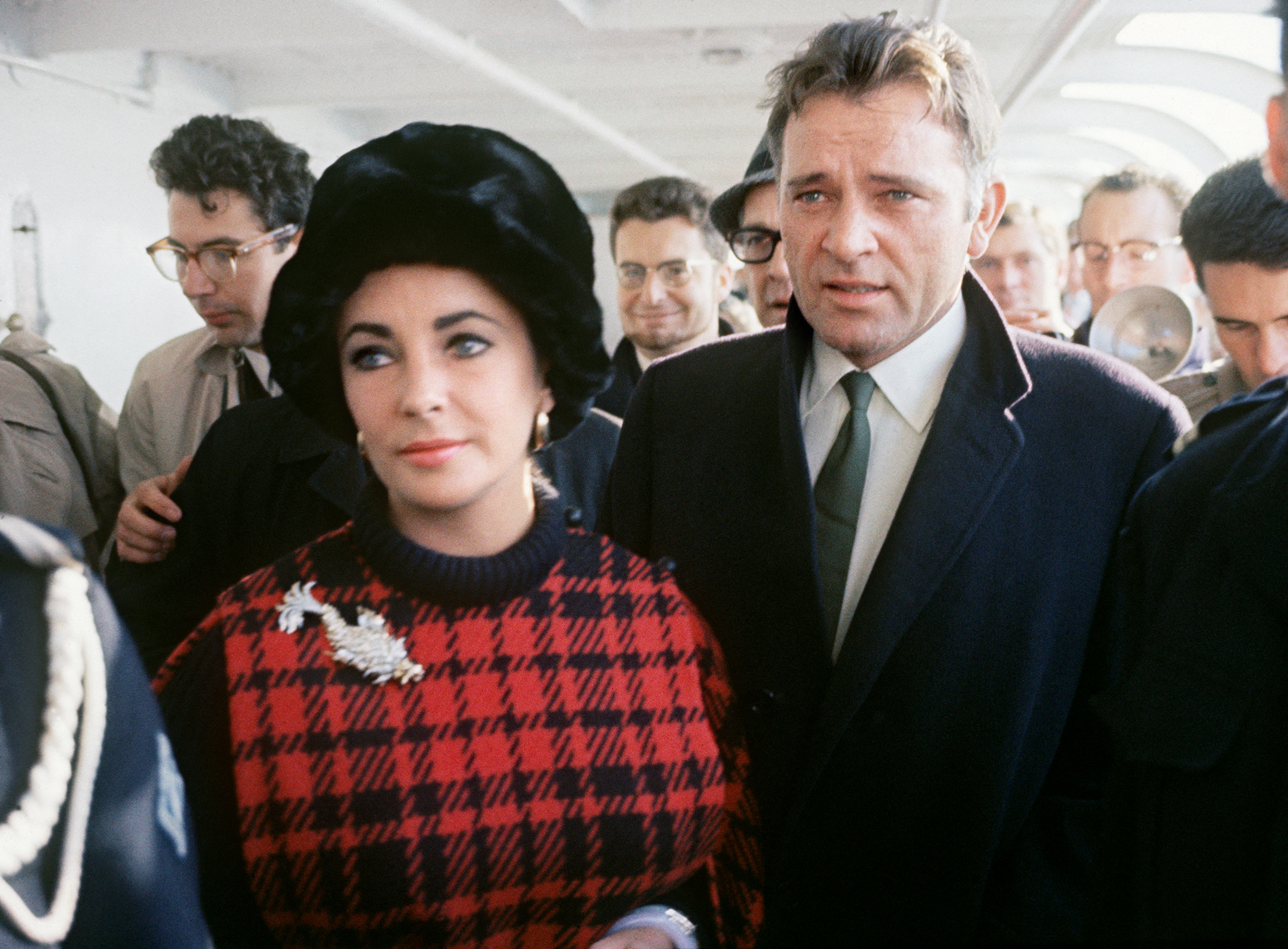 US actress Elizabeth Taylor (L) and her husband British actor Richard Burton are seen on the Transporter bridge in Cherbourg on October 12, 1964 during a trip in France. | Source: Getty Images