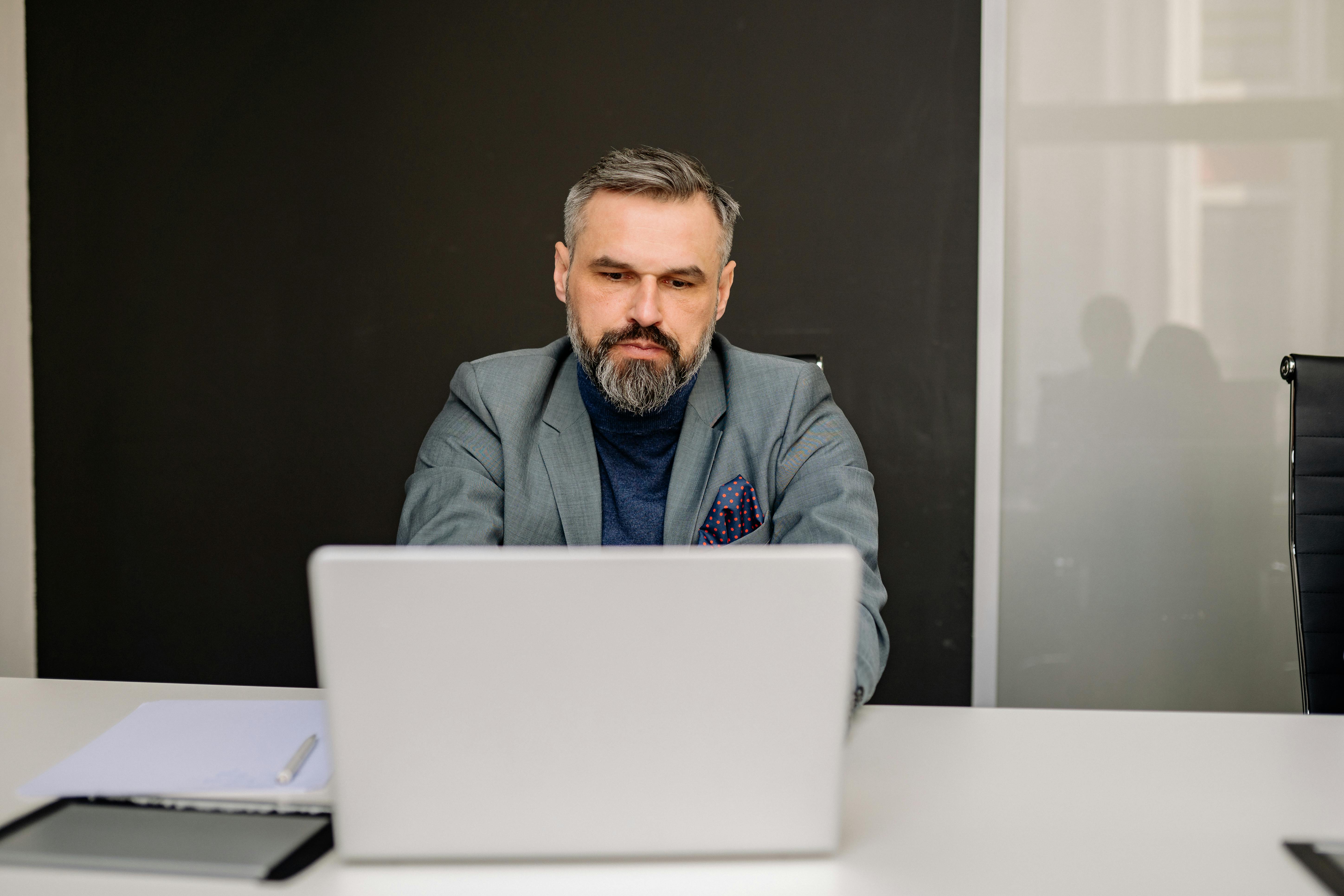 A serious man sitting with a laptop | Source: Pexels