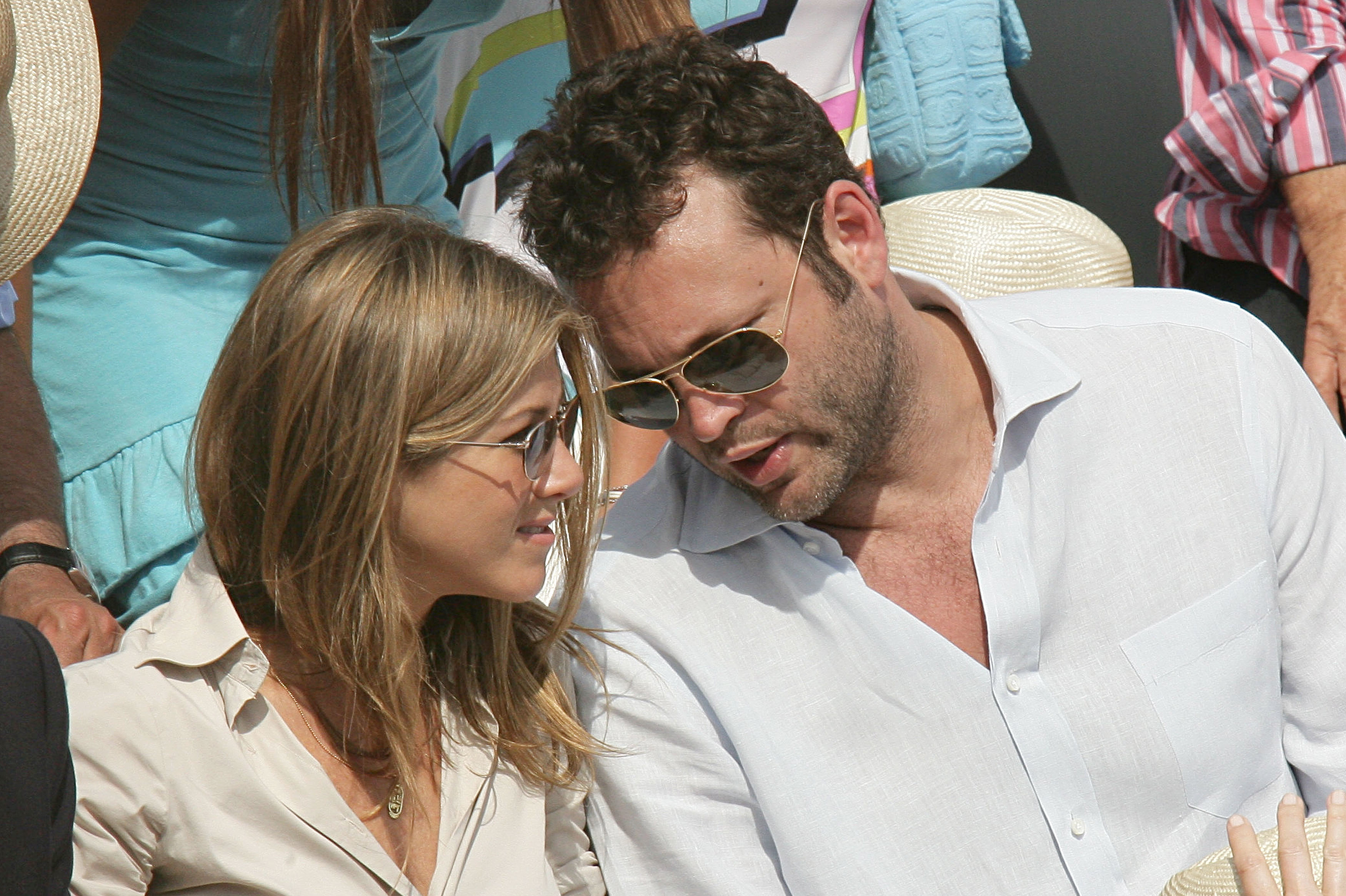 While attending the Roland Garros tennis tournament in June 2006, Jennifer Aniston sat beside Vince Vaughn during the match. She wore a white button-down shirt and sunglasses, her hair styled in soft waves with a natural, effortless look.