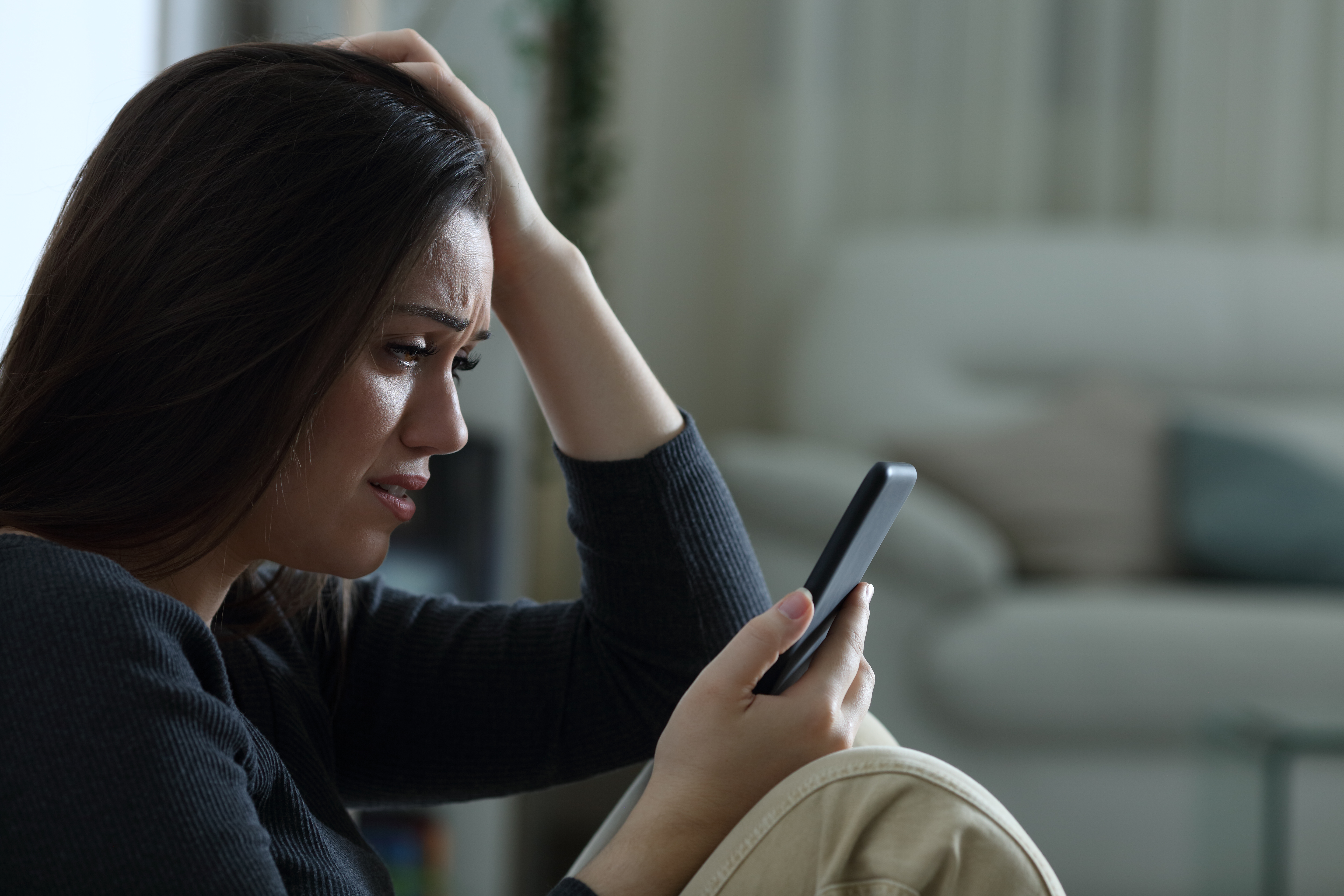 An upset woman looking at her phone | Source: Shutterstock
