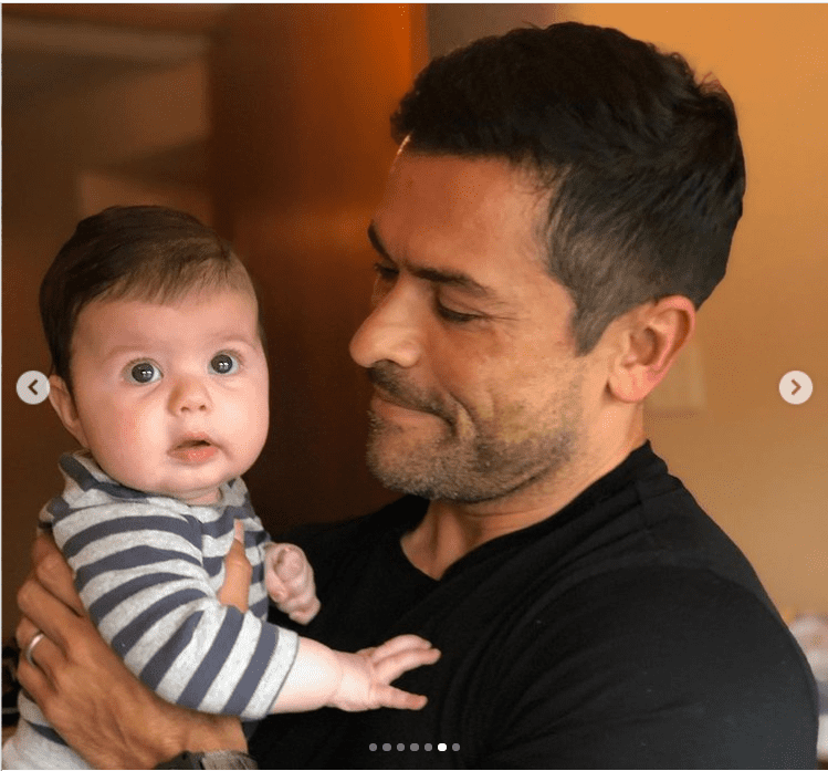 Mark Consuelos carries Andy Cohen's son, Ben, in his arms. | Photo: Instagram/andycohen