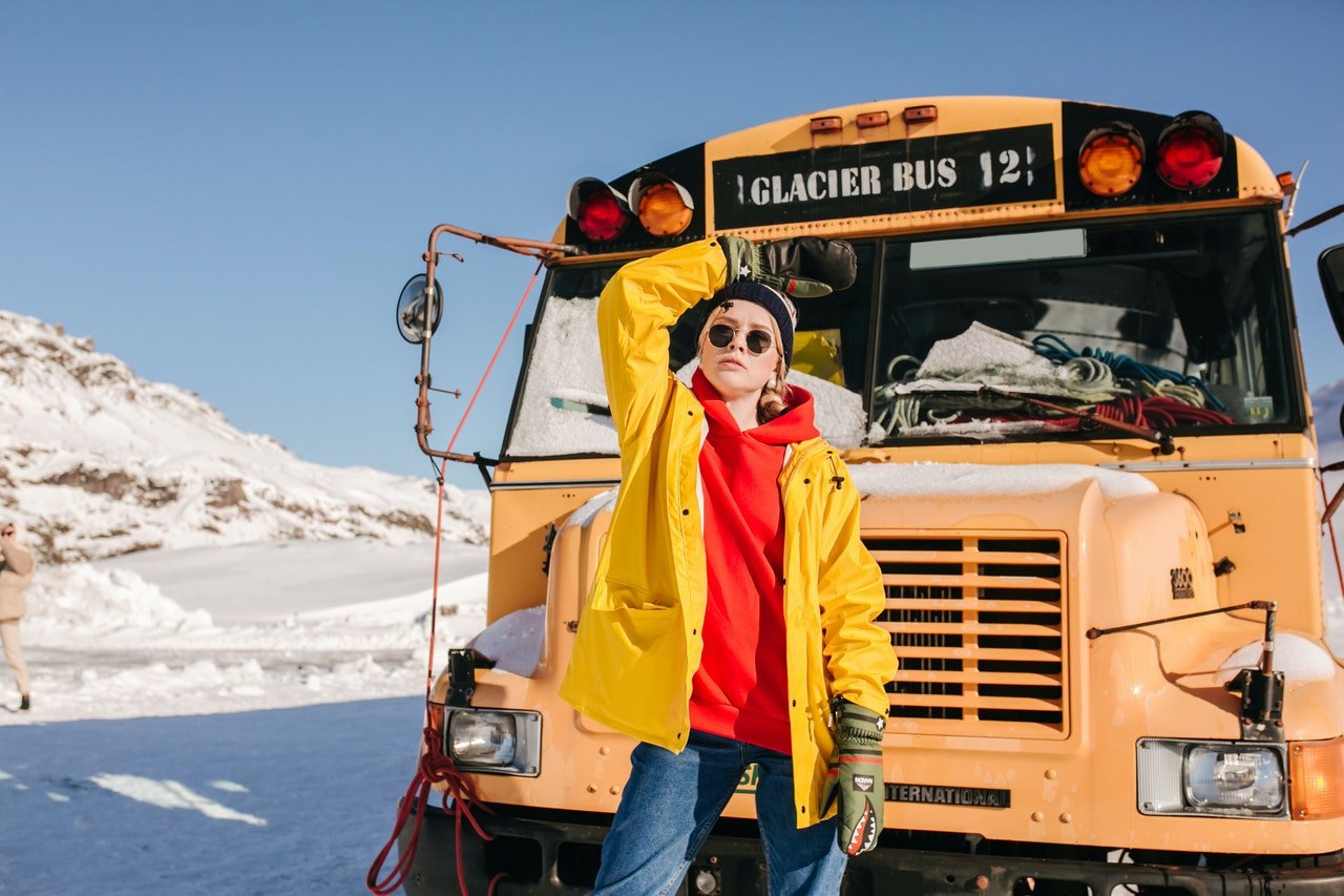 Un enfant posant devant un autobus scolaire. | Photo : Pexels
