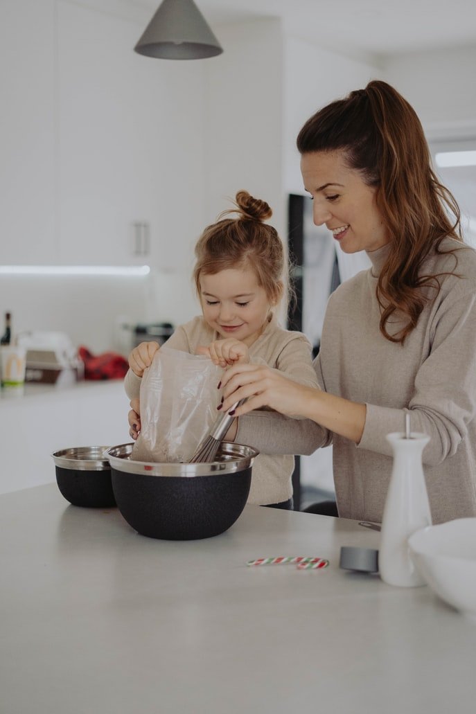 Child baking cookies with her mom| Photo: Getty Images