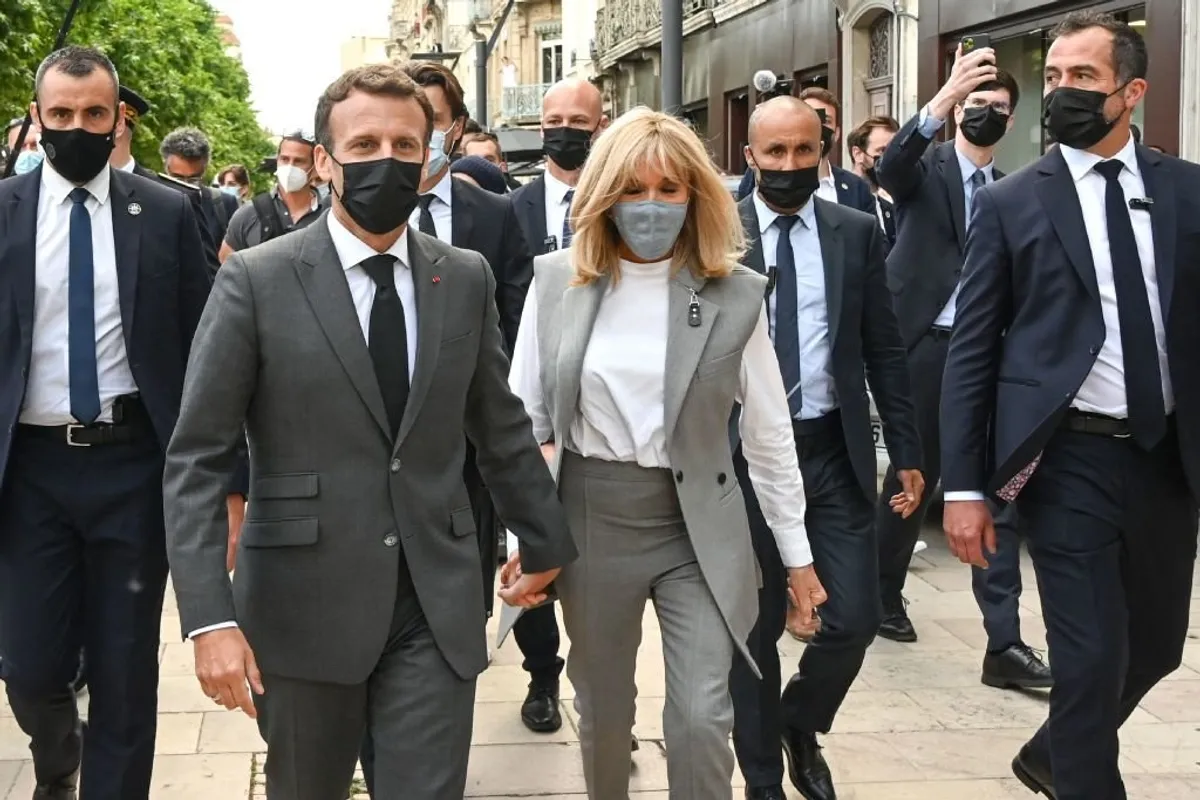 Le président français Emmanuel Macron (à gauche), son épouse Brigitte Macron (au centre) et le maire de Valence Nicolas Daragon (à droite) marchent dans une rue de Valence le 8 juin 2021 lors d'une visite dans le département de la Drôme. | Photo : Getty Images