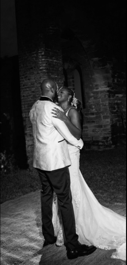 Captured in a romantic black-and-white moment, Nancy Metayer Bowen and her husband Stephen Bowen share a close embrace, smiling softly as they dance beneath the glow of evening lights on their wedding day. | Source: Facebook/Nancy Metayer Bowen