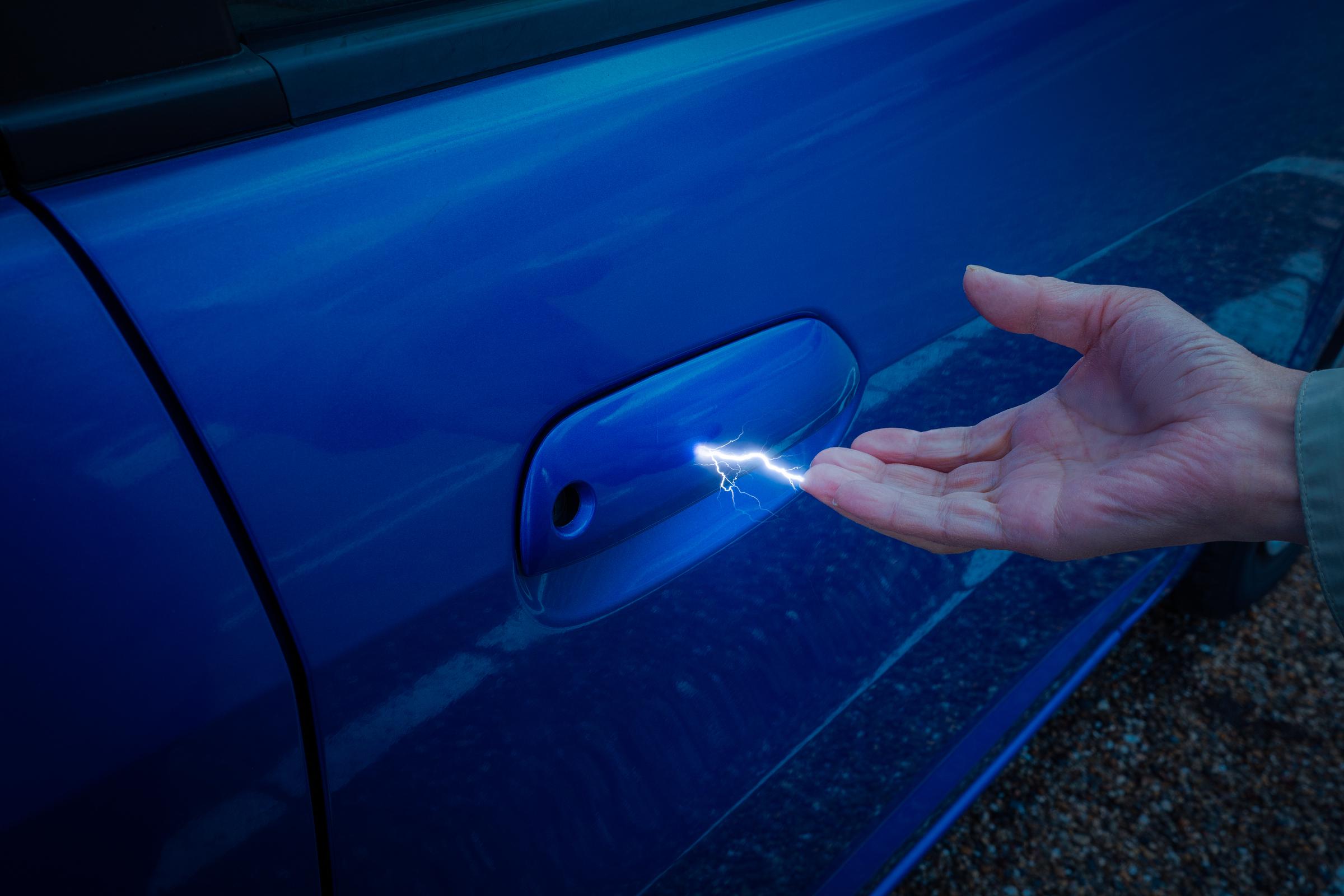 A visual of static electricity generated when a man reaches for a car door handle | Source: Getty Images