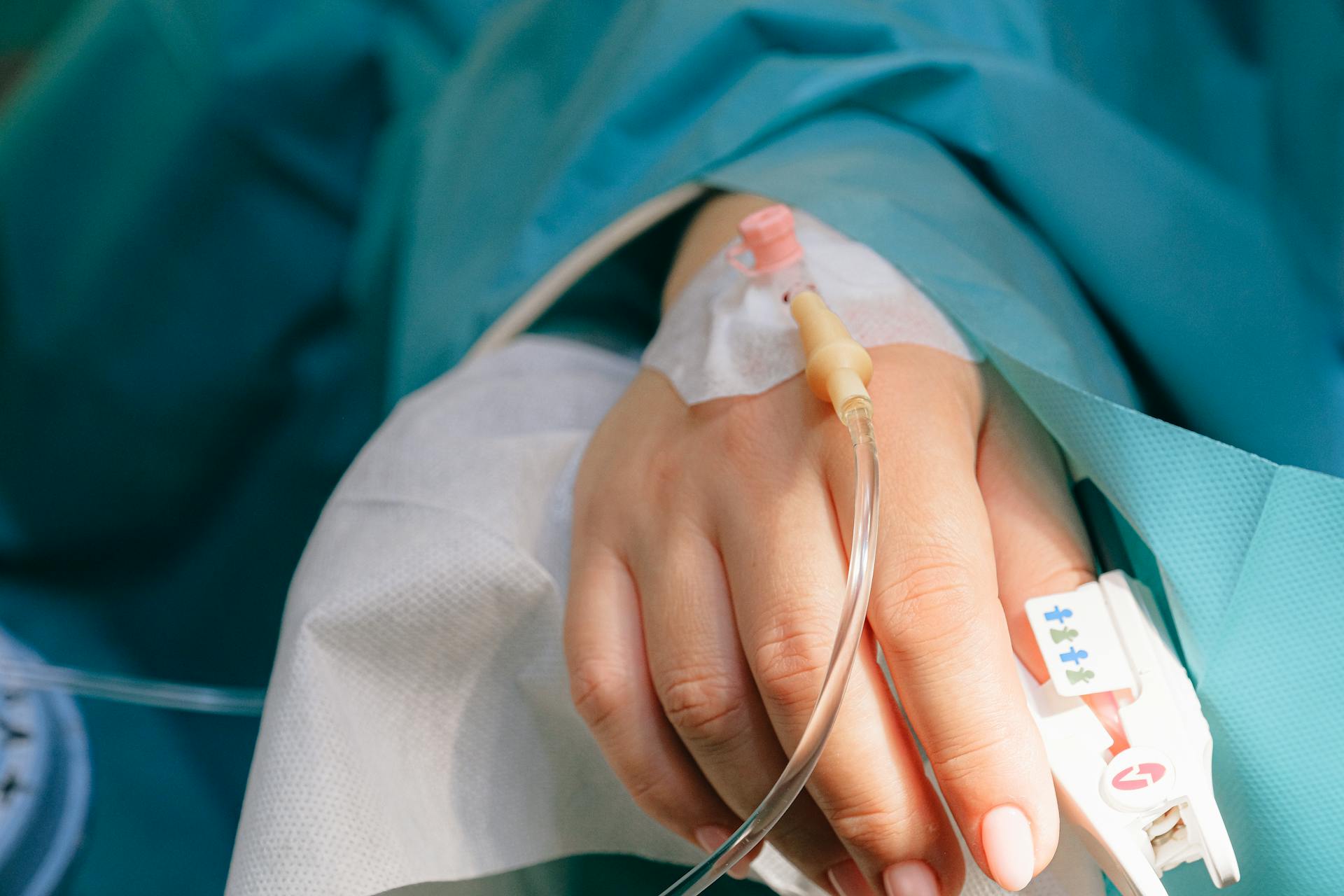 Close-up shot of woman's hand with IV line | Source: Pexels