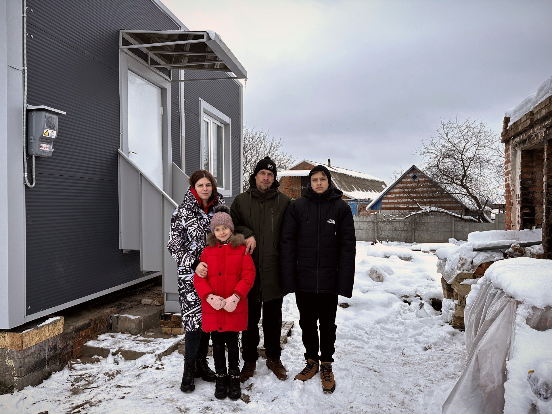 The family near their new modular home |  Source: NEST project