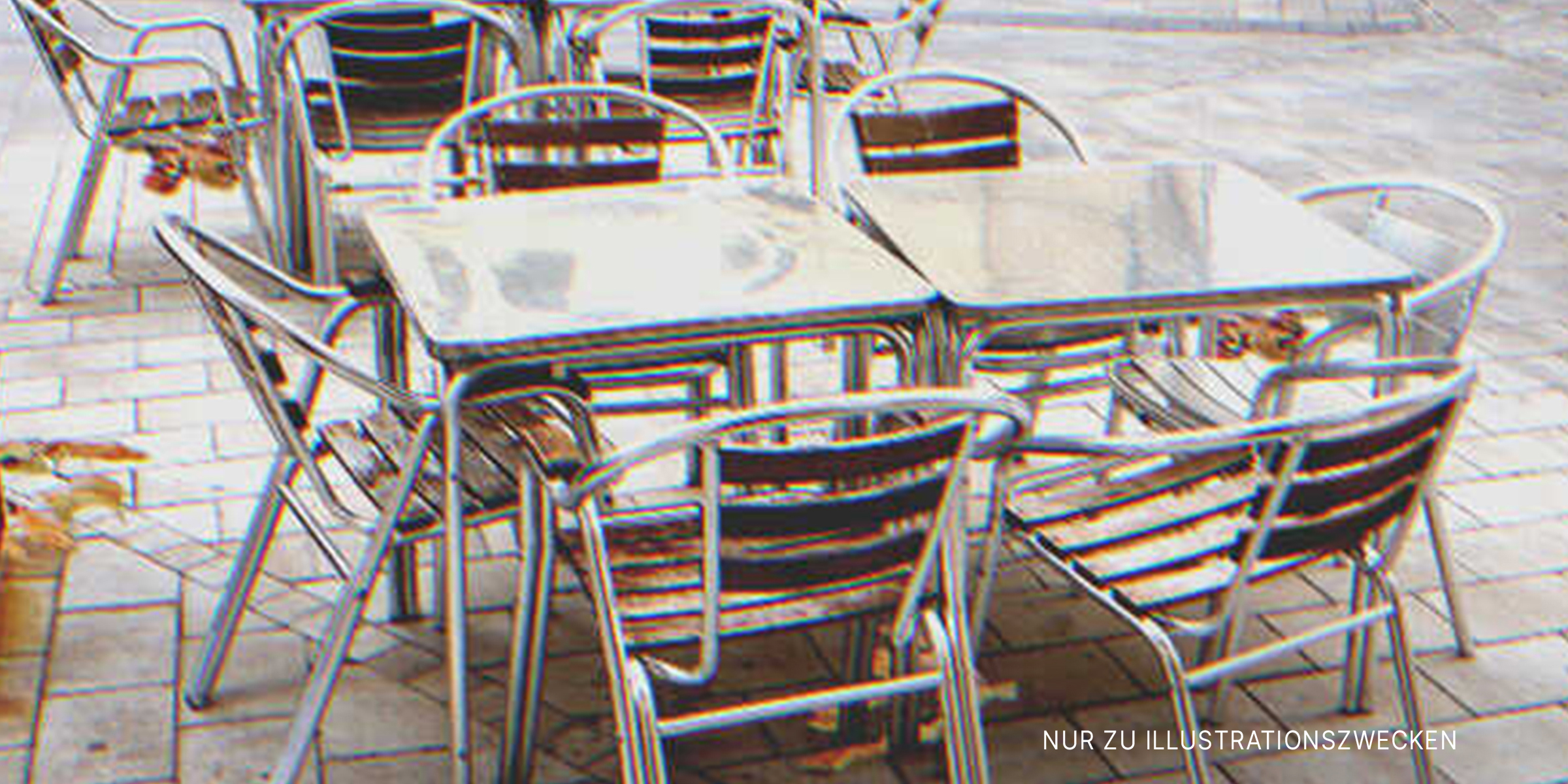 Metalltische und Stühle auf dem Bürgersteig vor einem Café. | Quelle: Getty Images