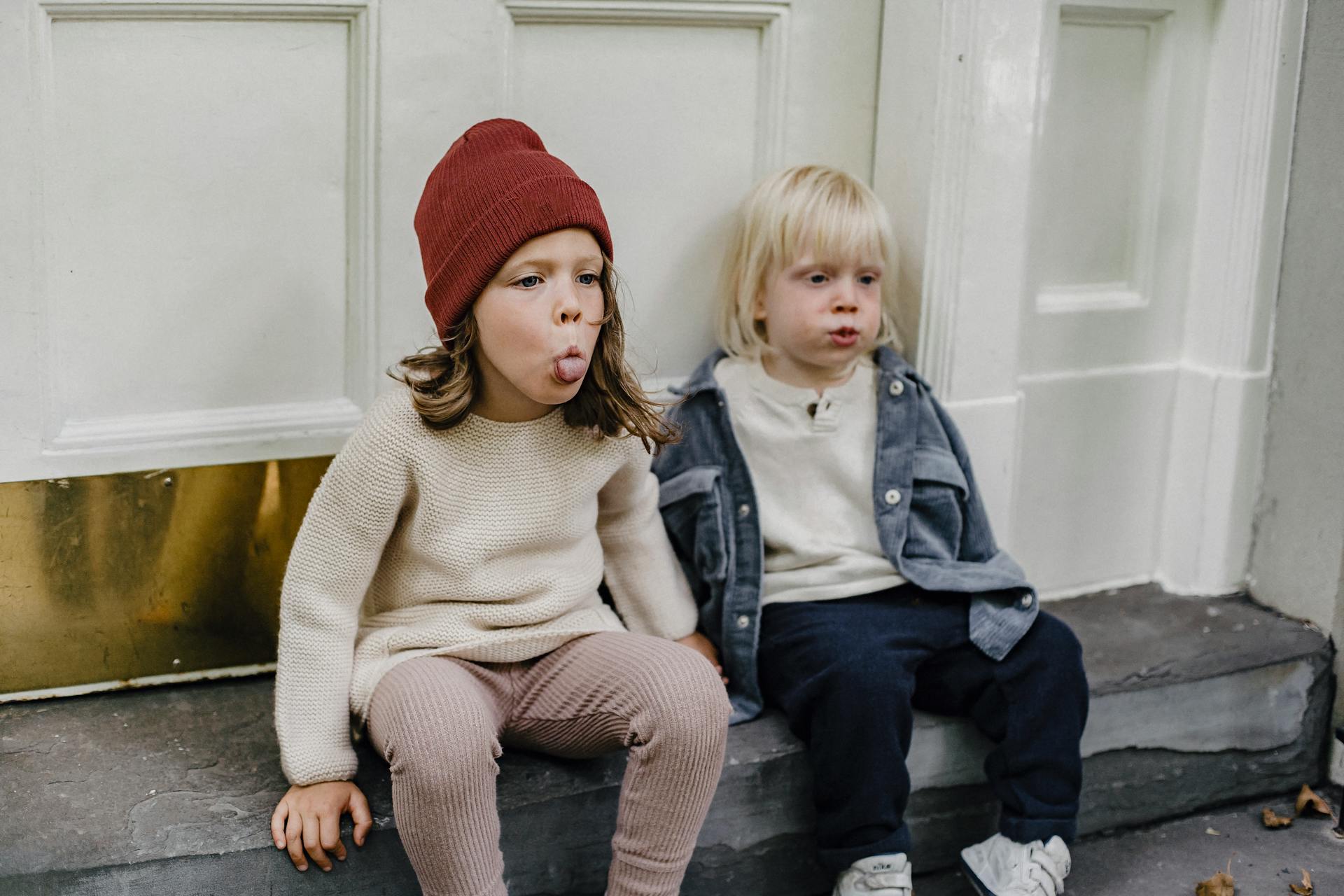 Two kids sitting on the porch making funny faces | Source: Pexels