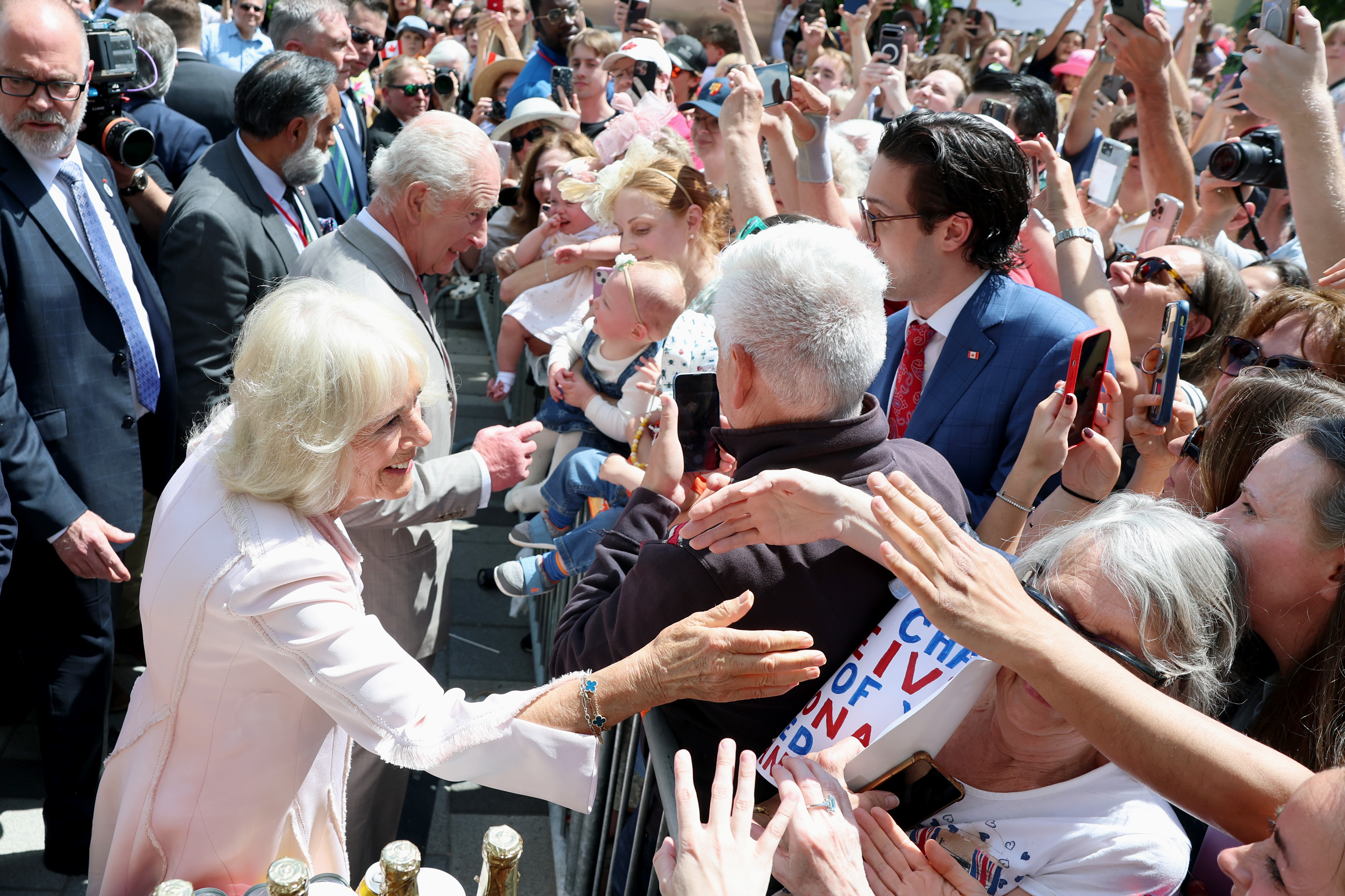 Afterwards, Queen Camilla and King Charles III attend a community event at Lansdowne Park, where they meet members of the public. The crowd is visibly excited and happy to see the royal couple, creating a warm and lively atmosphere.