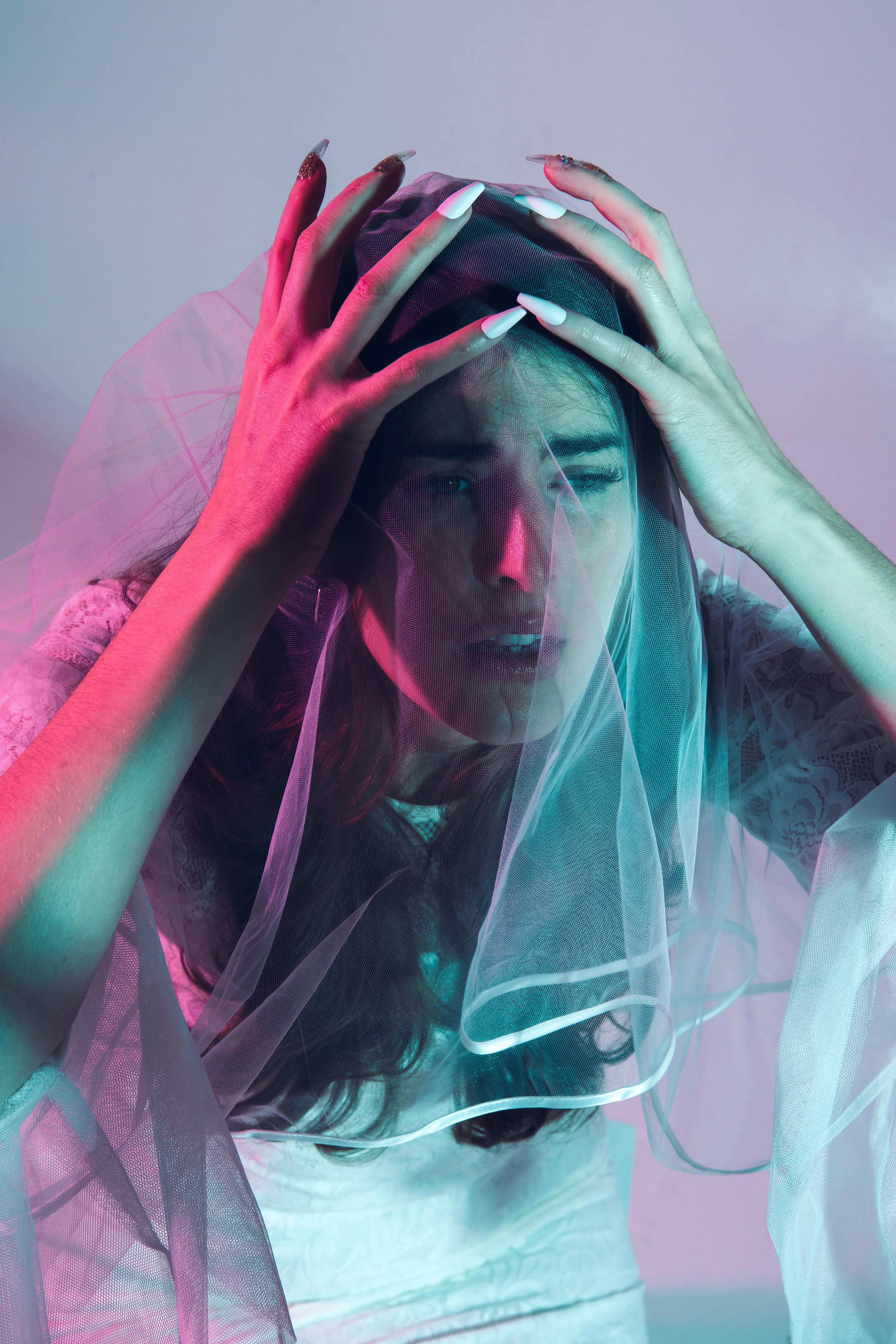 An upset bride holding her wedding gown veil | Source: Pexels