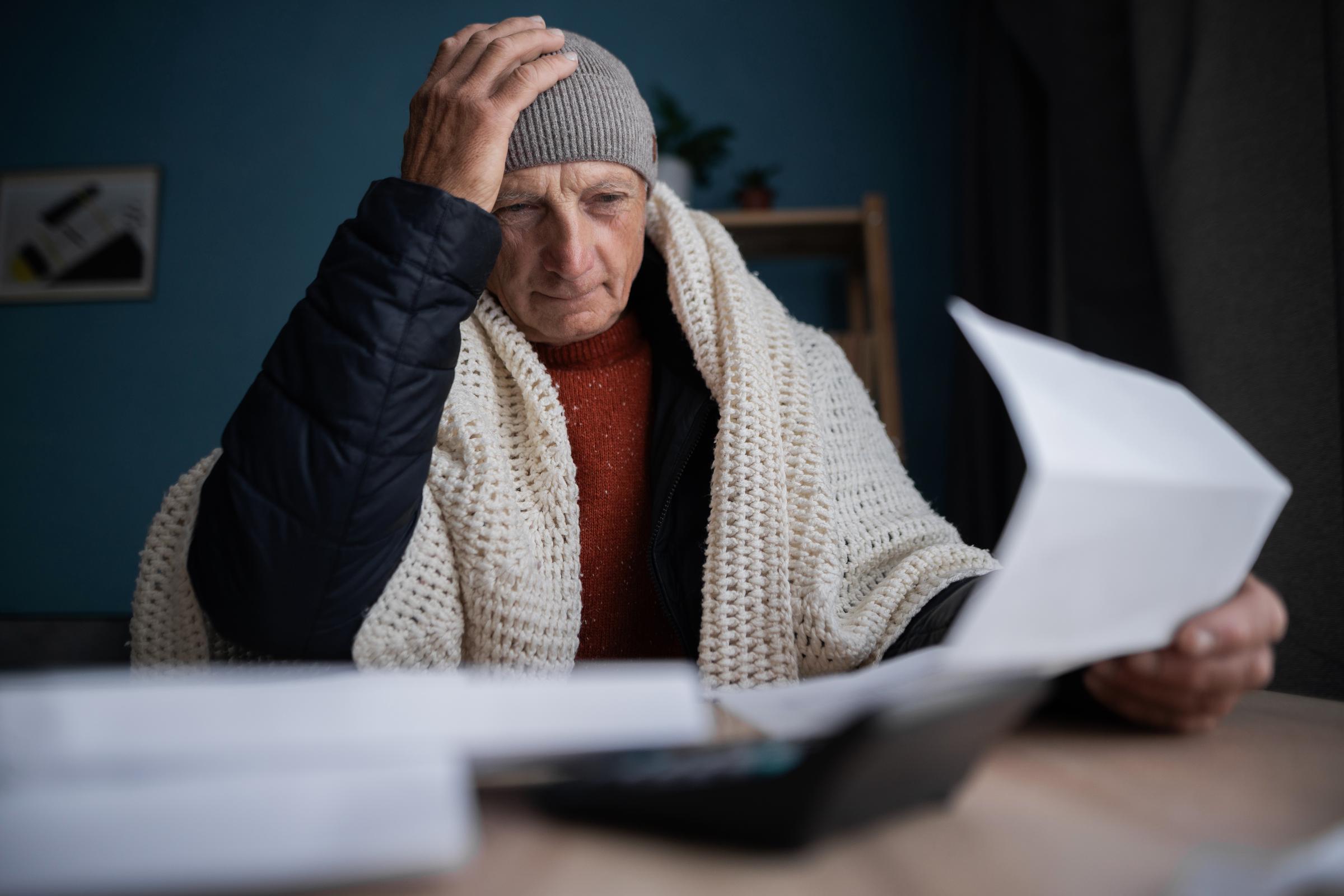 Man staring sadly at a document during the winter | Source: Shutterstock