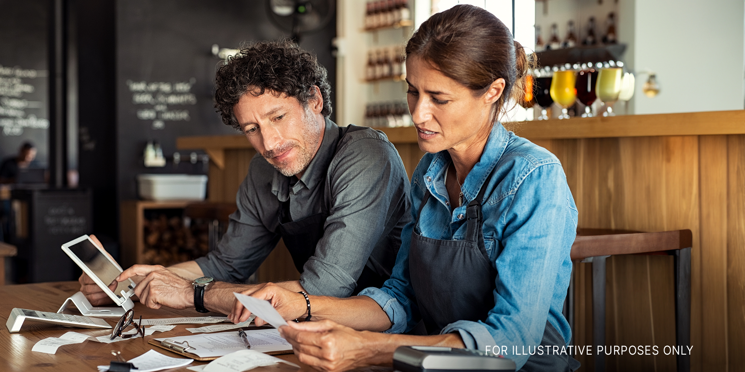A man a woman looking stressed while calculating receipts | Source: Shutterstock