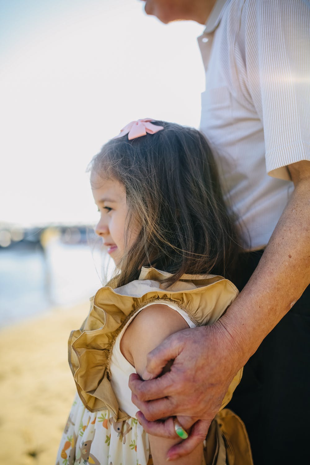 A little girl leaning against an old man. | Photo: Pexels